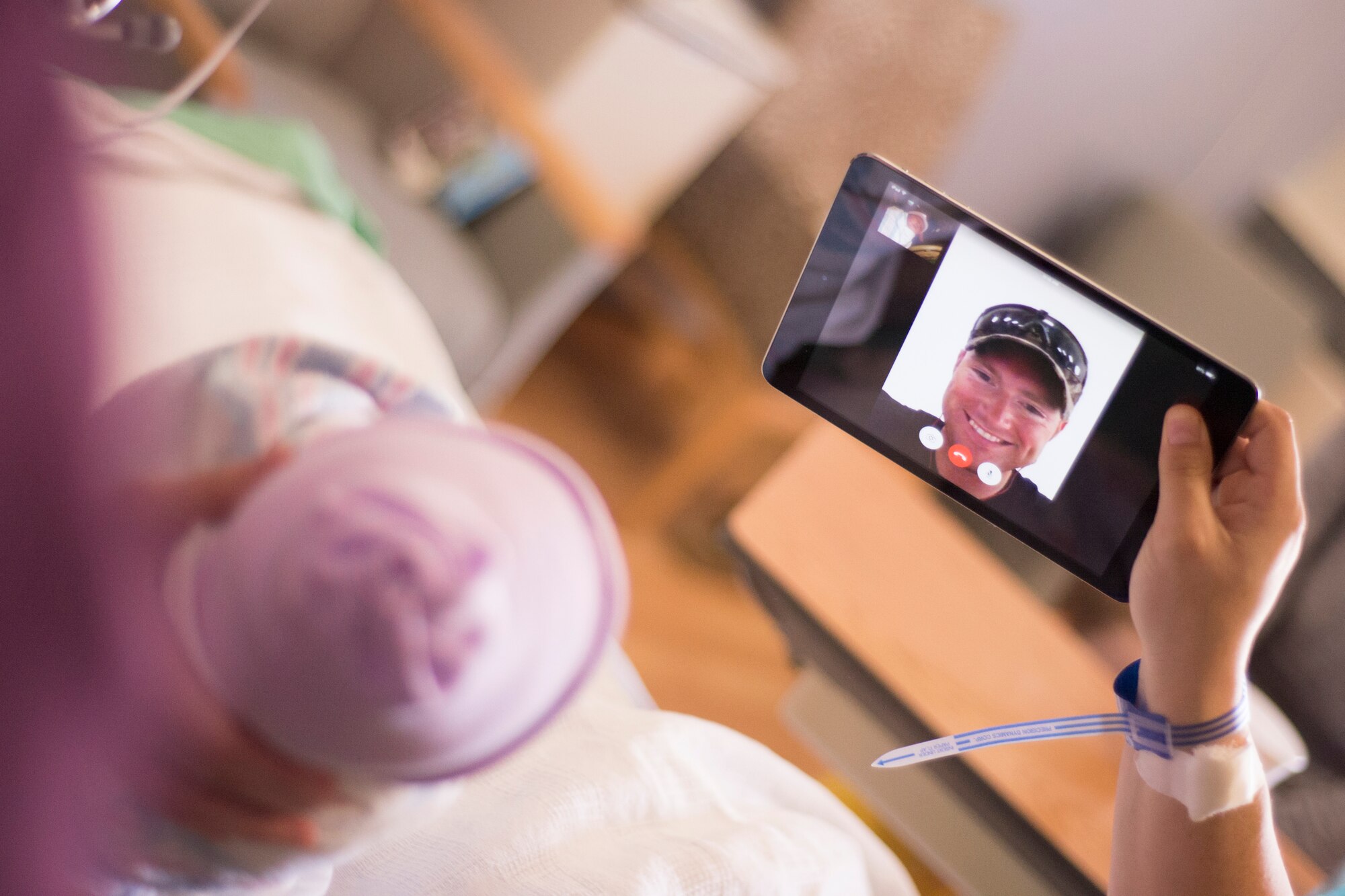 Airman 1st Class Bryan Pfeifer, 48th Civil Engineer Squadron heavy equipment operator, sees his son for the first time via FaceTime at Royal Air Force Lakenheath, England, April 23, 2015. Newly-implemented Wi-Fi throughout the base allowed family members to communicate around the world during a priceless moment. (U.S. Air Force photo by Carly Moon-Warnick)