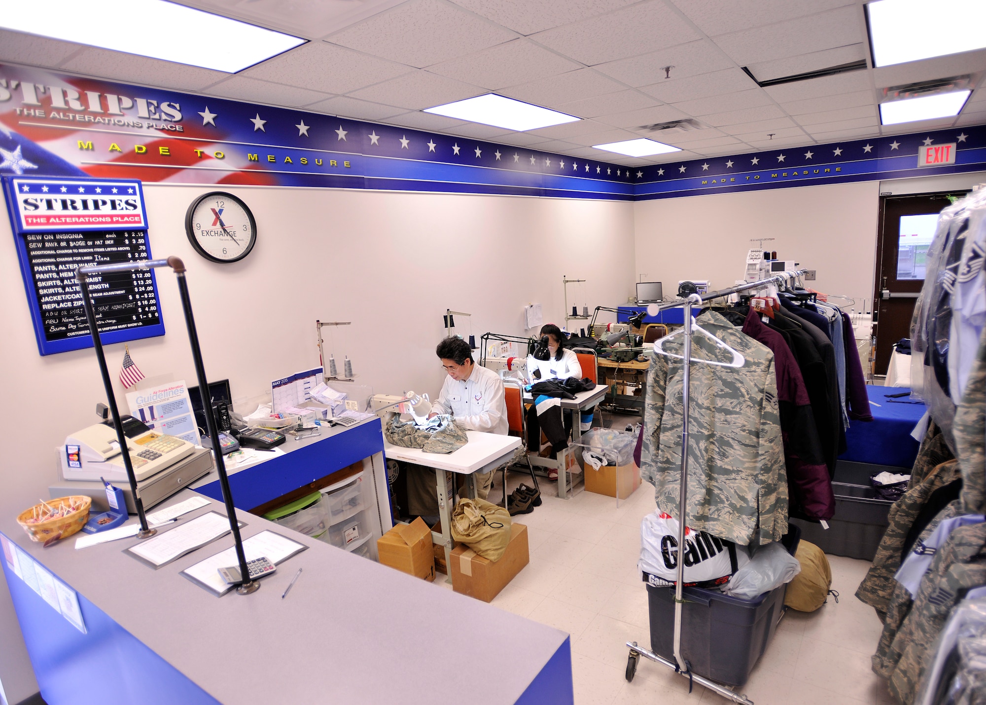 Kin Fat Lai, Exchange alterations manager, and his wife and co-worker Ai Ling Lai, work together to get uniforms and clothes done in a timely manner on May 7, 2015, on Grand Forks Air Force Base, N.D. The alterations shop sews on new pieces of clothing from patterns and designs and also alters existing garments to fit a customer better. (U.S. Air Force photo by Senior Airman Xavier Navarro/released)