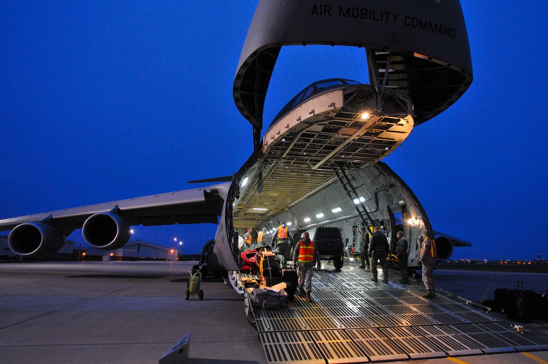 Members of the 114th Logistics Readiness Squadron assist C-5 Galaxy crewmembers load equipment during the early morning hours May 11, 2015 at Joe Foss Field. The South Dakota Air National Guard’s 114th Fighter Wing prepares to deploy almost 250 members on a four month deployment to South Korea where they will support the United States' continual commitment to stability and security in the region. (National Guard photo by Staff Sgt. Luke Olson/Released)