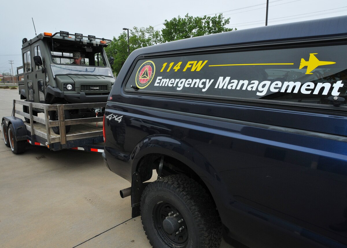 U.S. Air Force Airman 1st Class Jacob Beukelman, 114th Civil Engineer heavy equipment operator, loads a utility terrain vehicle to transport to Delmont, S.D., May 11, 2015. Approximately 20 members of the 114th CE Squadron were activated by South Dakota Gov. Dennis Daugaard to assist with tornado recovery efforts in the community. (U.S. Air National Guard photo by Staff Sgt. Luke Olson/Released)