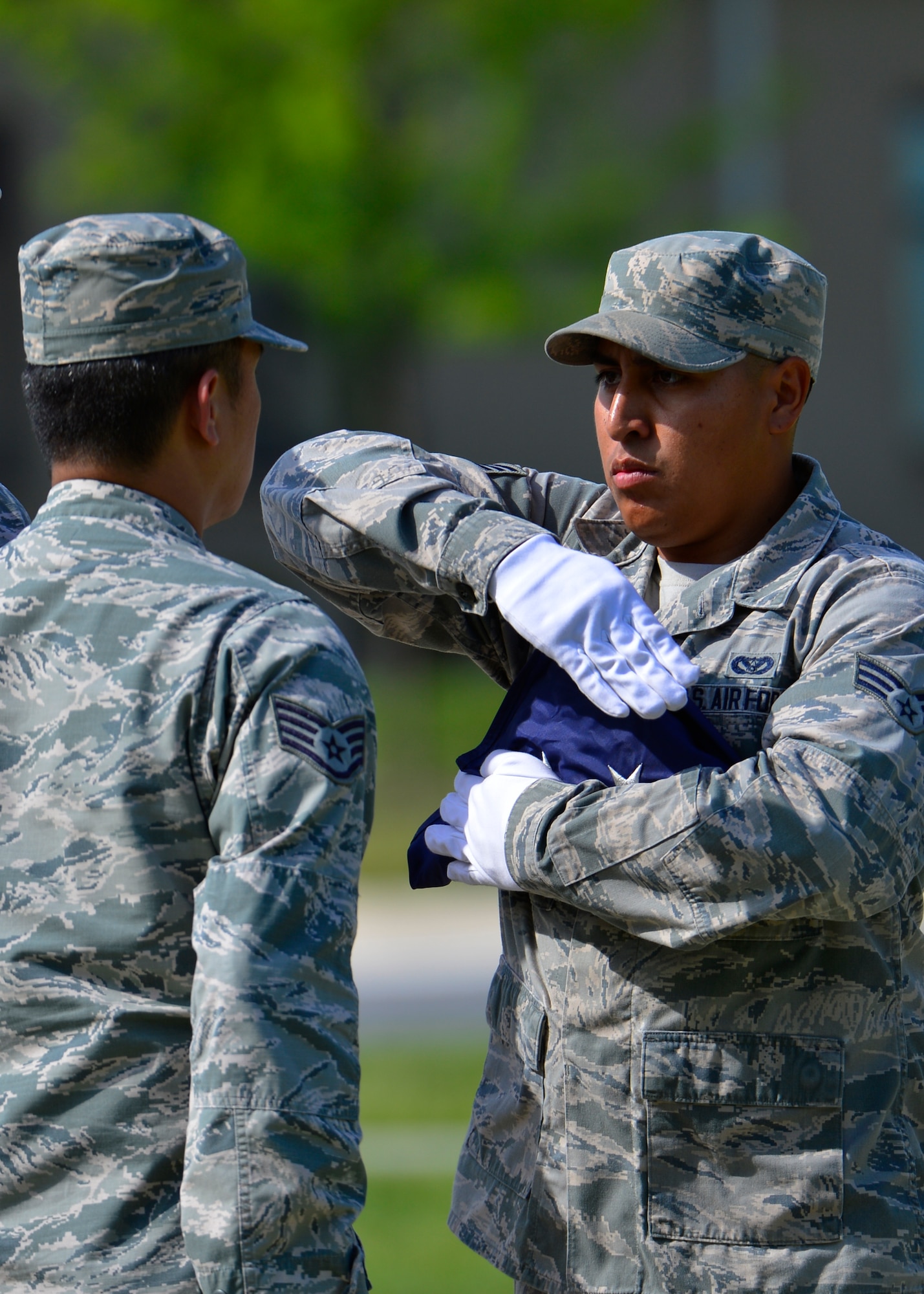 Senior Airman Alex Ventura, 436th Civil Engineer Squadron structural journeyman, right, dresses the flag while Staff Sgt. Leopoldo Lardizabal, 436th CES structural craftsman, left, looks on during a retreat ceremony May 8, 2015, at Dover Air Force Base, Del. Retreat ceremonies are held on Fridays during the summer months and are conducted by different units on base. (U.S. Air Force photo/Airman 1st Class William Johnson)