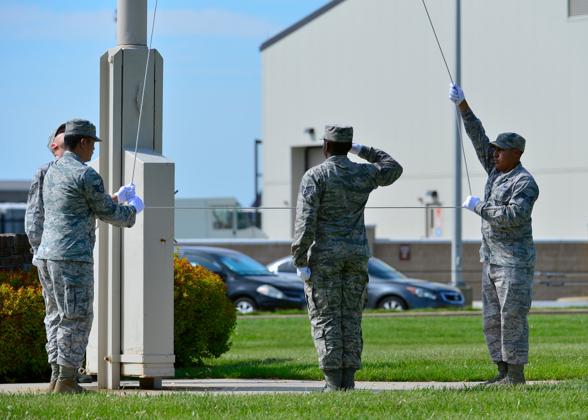 Staff Sgt. Kareem Wilson, 436th Civil Engineer Squadron electrical systems craftsman, center, renders a salute while Staff Sgt. Leopoldo Lardizabal, 436th CES structural craftsman, left, and Senior Airman Alex Ventura, 436th CES structural journeyman, right, lower the flag during a retreat ceremony May 8, 2015, at Dover Air Force Base, Del. The 436th CES conducted the first retreat ceremony of the year. (U.S. Air Force photo/Airman 1st Class William Johnson)