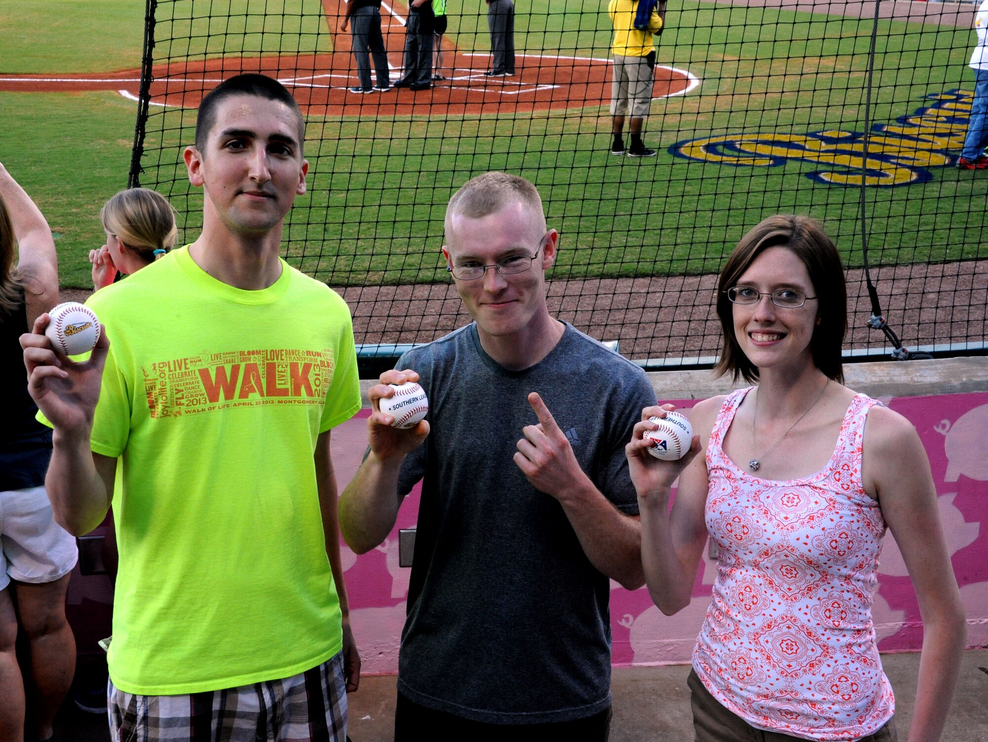 Senior Airman Vincent Glenn-Stone, left, Senior Airman James Sottile, center, and Staff Sgt. Shelby Vande Zande, right, from Maxwell Air Force Base show off souvenir baseballs they received for throwing out the first pitch during a Montgomery Biscuits baseball game, Montgomery, Alabama, May 6, 2015. The Airmen were selected to throw out the first pitch for being Air Education and Training Command’s 2015 12 Outstanding Airmen of the Year Award recipients. (U.S. Air Force photo by Airman 1st Class Alexa Culbert/Cleared)