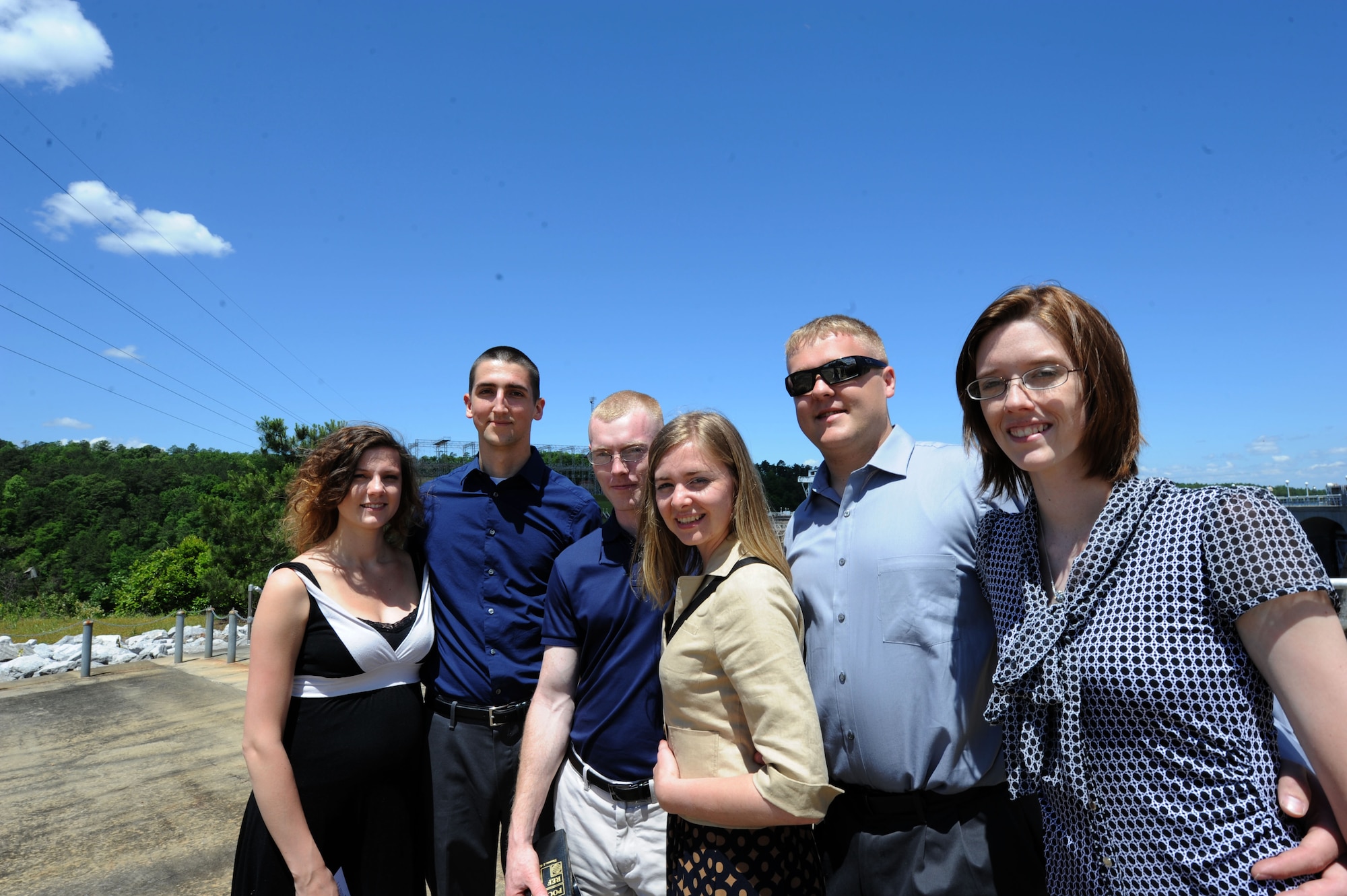 Air Education and Training Command’s 2015 12 Outstanding Airmen of the Year Award recipients from Maxwell Air Force Base pose for a picture with their spouse near the Alabama Power Company’s Martin Dam located near Dadeville, Alabama, in the counties of Elmore and Tallapoosa, May 6, 2015. During the tour, the Airmen went inside the 168-feet-high and 2,000-feet-long dam to see how it works. Award recipients were Senior Airman Vincent Glenn-Stone (second from left) Honor Guard category, Senior Airman James Sottile (third from left) Airman category, and Staff Sgt. Shelby Vande Zande (far right) NCO category. (U.S. Air Force photo by Airman 1st Class Alexa Culbert/Cleared)
