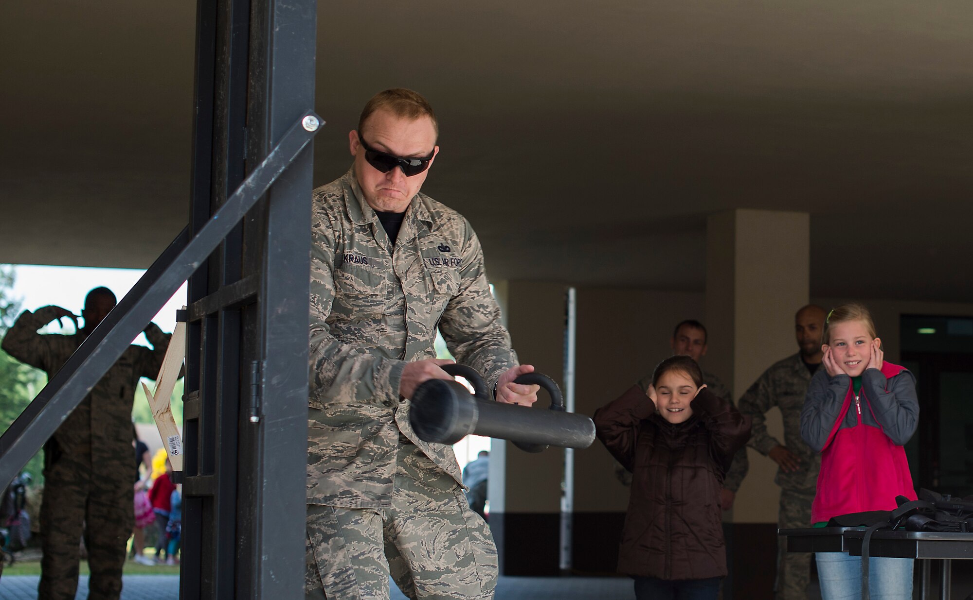 Staff Sgt. Stephen Kraus, 435th Security Forces Squadron Battlefield Leader Assaulter Course Integrated Combat Essentials breacher, demonstrates how to break through a door during Job Shadow Day May 8, 2015, at Ramstein Air Base, Germany. Kraus showed the attendees a variety of breaching equipment that the 435th SFS is trained to use. (U.S. Air Force photo/Senior Airman Damon Kasberg)