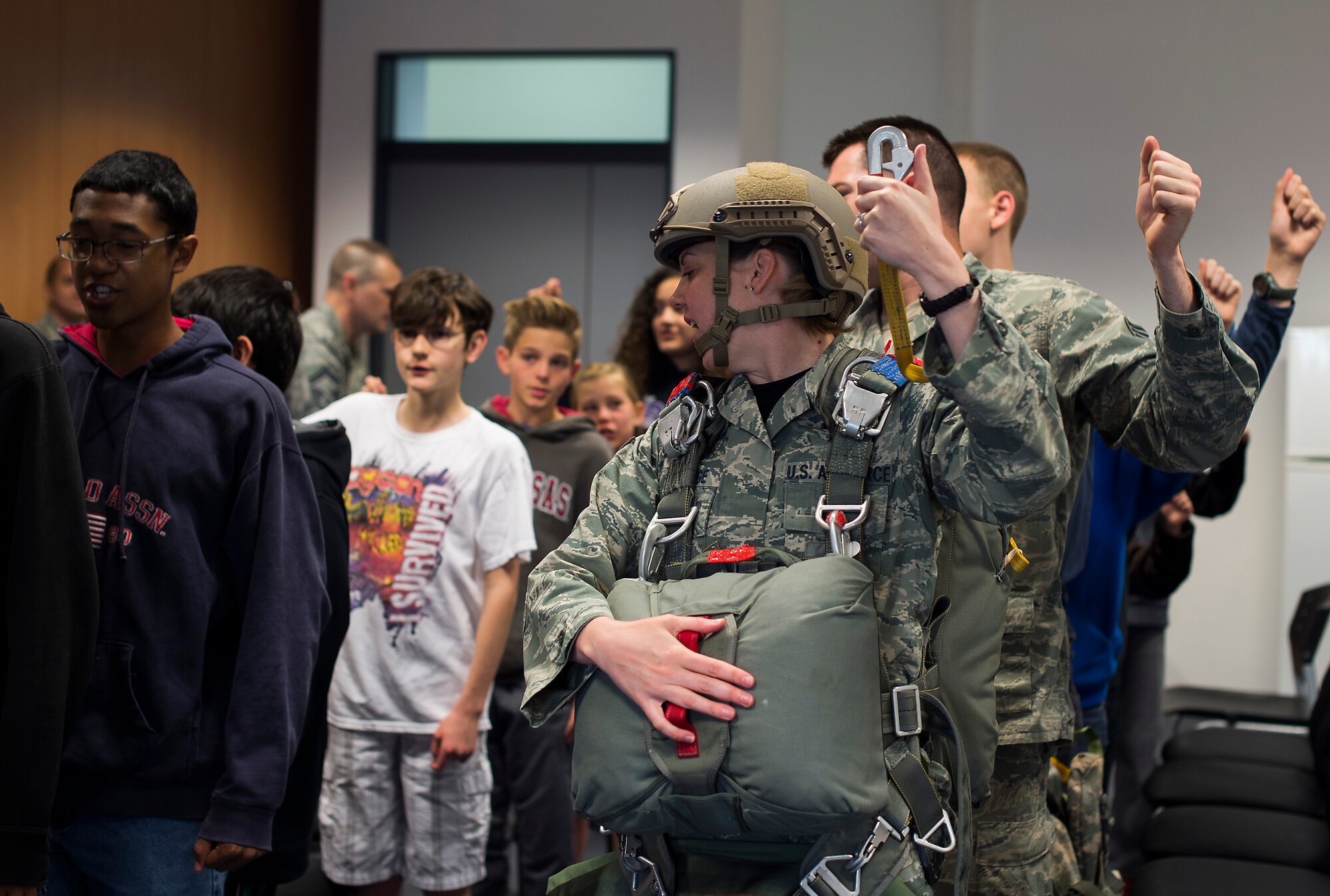 Staff Sgt. Megan Gulledge, 435th Security Force Squadron deployment operations training NCO in charge, demonstrates how paratroopers exit an aircraft during Job Shadow Day May 8, 2015, at Ramstein Air Base, Germany. Members for the 435th SFS showed attendees many aspects of being a paratrooper, including gear, jumping and landing procedures. (U.S. Air Force photo/Senior Airman Damon Kasberg) 