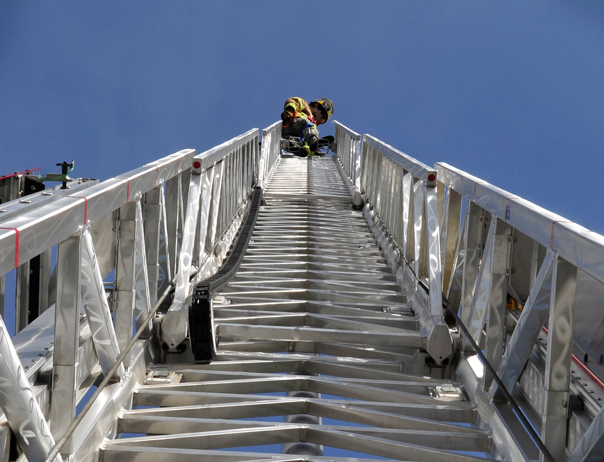 Senior Airman Mark Morris, 86th Civil Engineer Squadron fire truck operator, climbs to the top of a fire truck ladder to demonstrate its capability during Job Shadow Day May 8, 2015, at Ramstein Air Base, Germany. The 86th CES firefighters train with partner nations to enhance their skills for real-world emergencies. (U.S. Air Force photo/Airman 1st Class Larissa Greatwood)