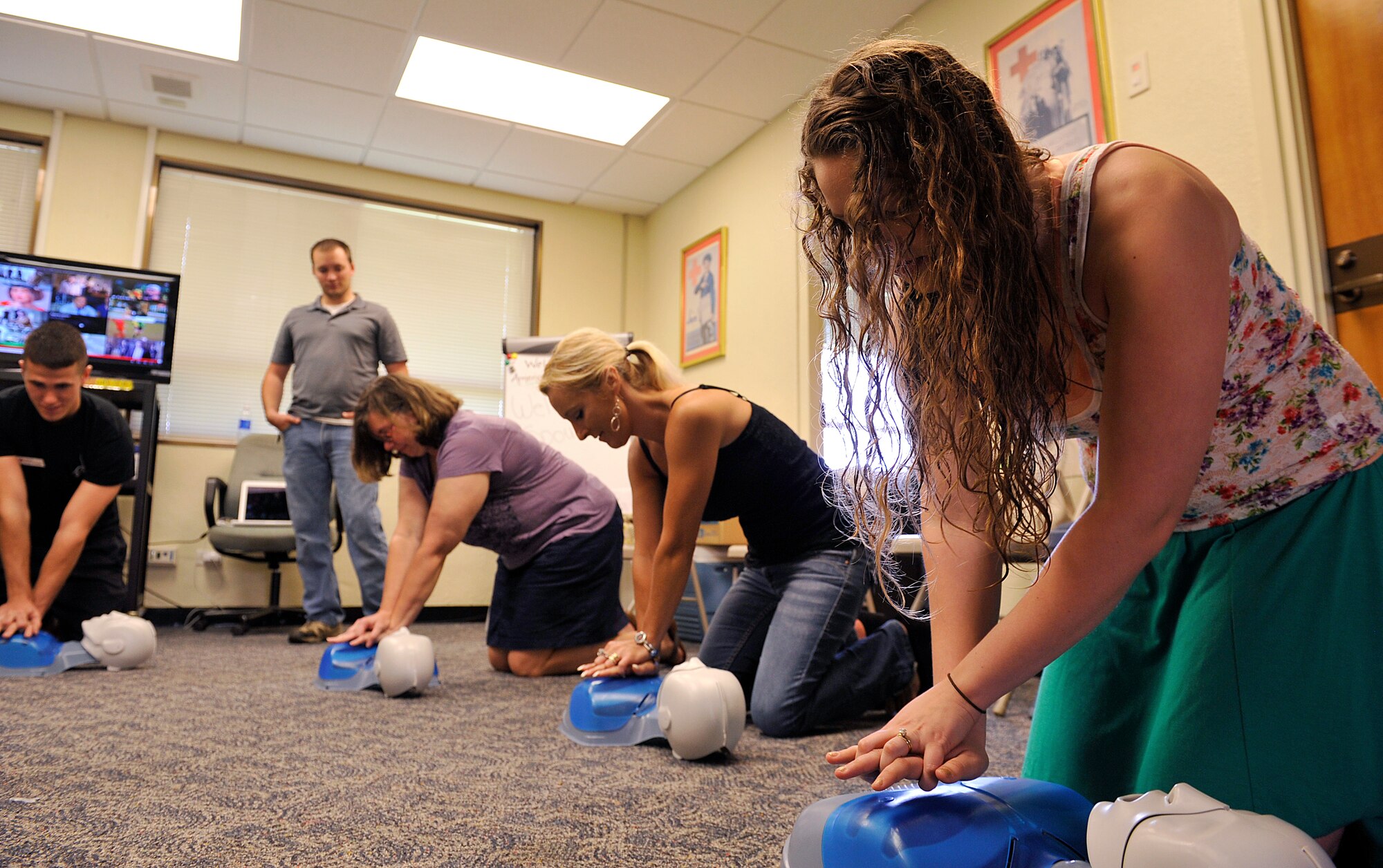 Military spouses practice chest compressions on a CPR mannequin during Military Spouse Appreciation Day at the American Red Cross on Kadena Air Base, Japan, May 8, 2015. Military Spouse Appreciation Day was created to recognize military spouses each year for their hard work and dedication to the armed forces. (U.S. Air Force photo by Naoto Anazawa)