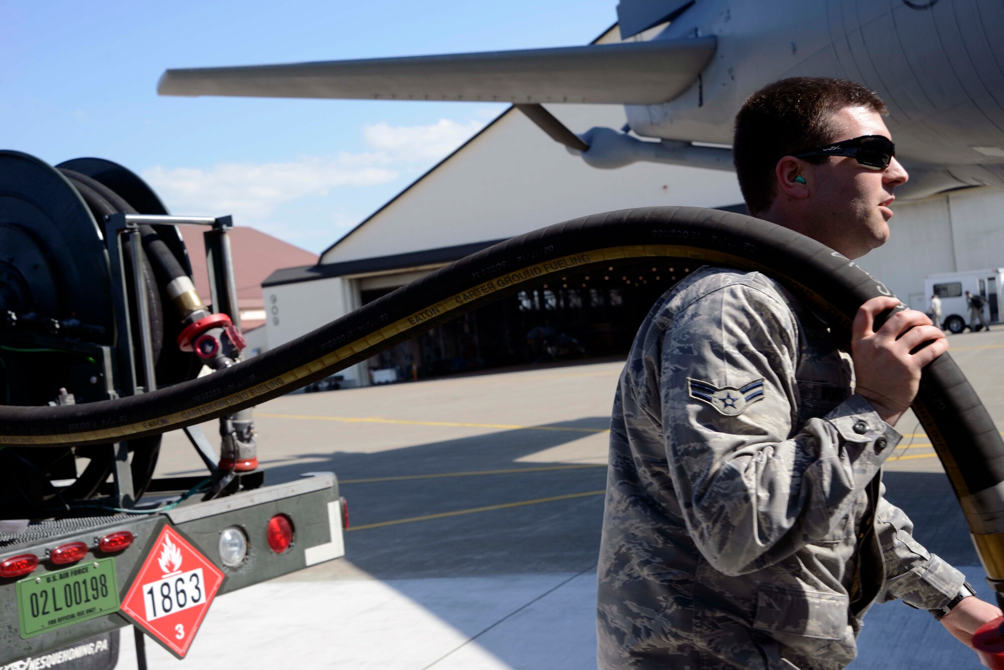 U.S. Air Force Airman 1st Class David Works, 35th Logistics Readiness Squadron fuels distribution operator, carries a fuel hose from an R-12 fuel servicing truck to a KC-135 Stratotanker at Misawa Air Base, Japan, May 11, 2015. Misawa celebrated the installation of a Type III hydrant fuel system during a ribbon cutting ceremony earlier in the day before refueling multiple aircraft with the new system. (U.S. Air Force photo by Staff Sgt. Derek VanHorn/Released)