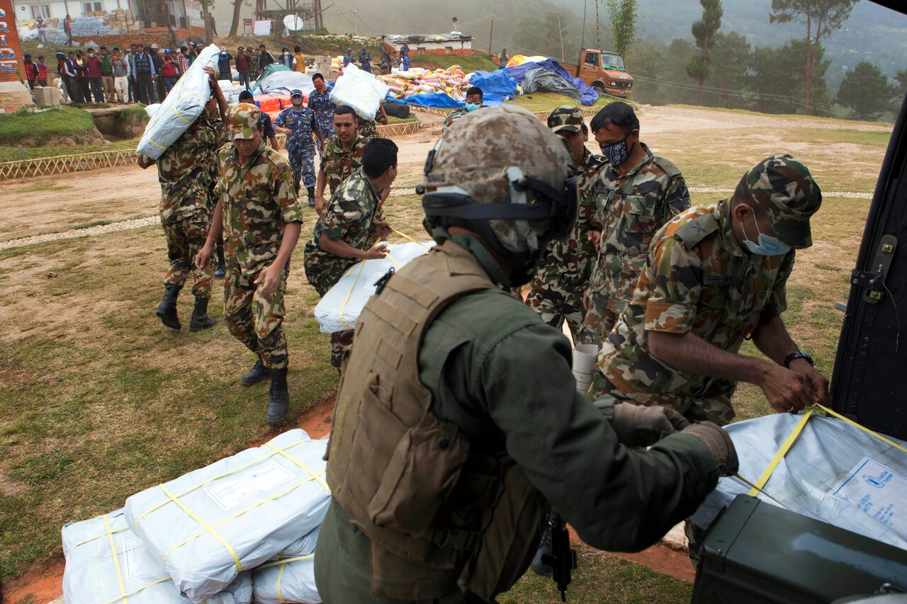 Nepalese service members gather earthquake relief supplies delivered by members of Joint Task Force 505 at an outlying village near Kathmandu, Nepal, May 7, 2015. U.S. Marine Corps photo by Staff Sgt. Jeffrey D. Anderson