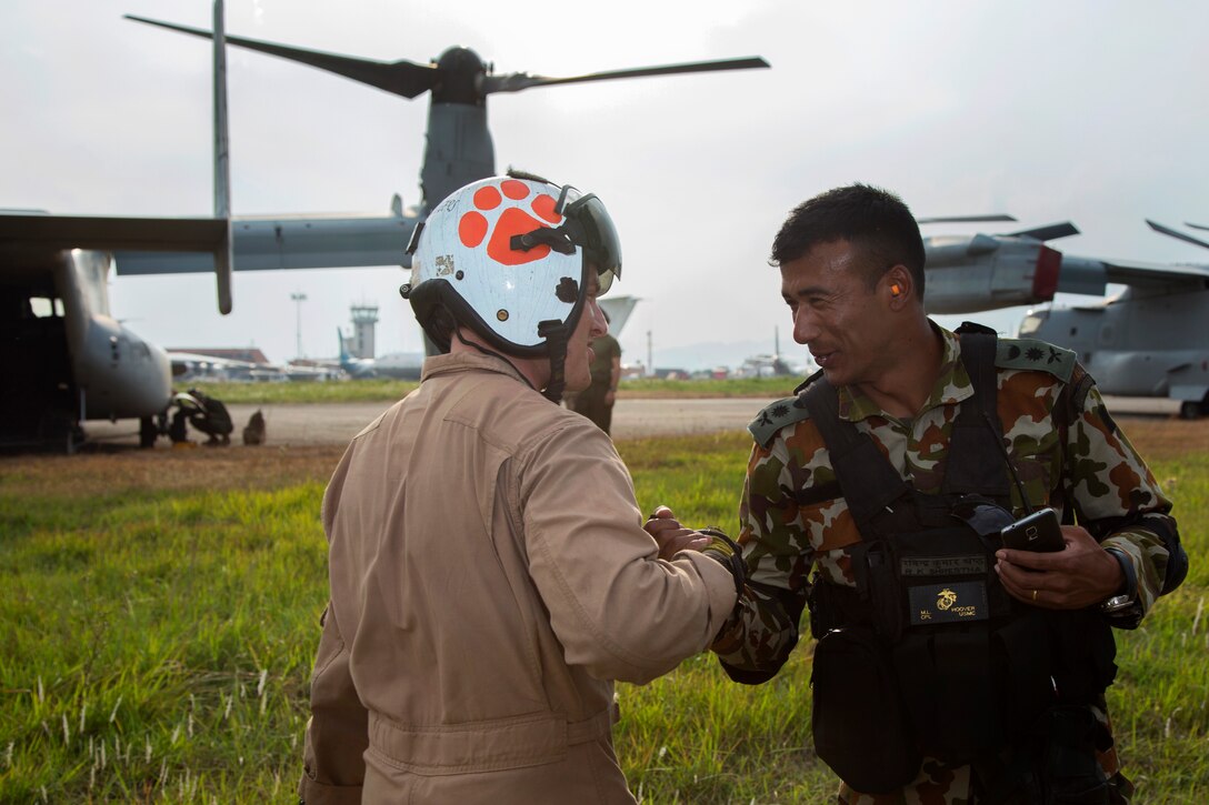 U.S. Marine Corps Cpl. Mitch Hoover, left, shakes hands with Nepalese army Capt. Rabindra Shrestha at Tribhuvan International Airport, Kathmandu, Nepal, May 11, 2015. Hoover is a crew chief assigned to Joint Task Force 505.