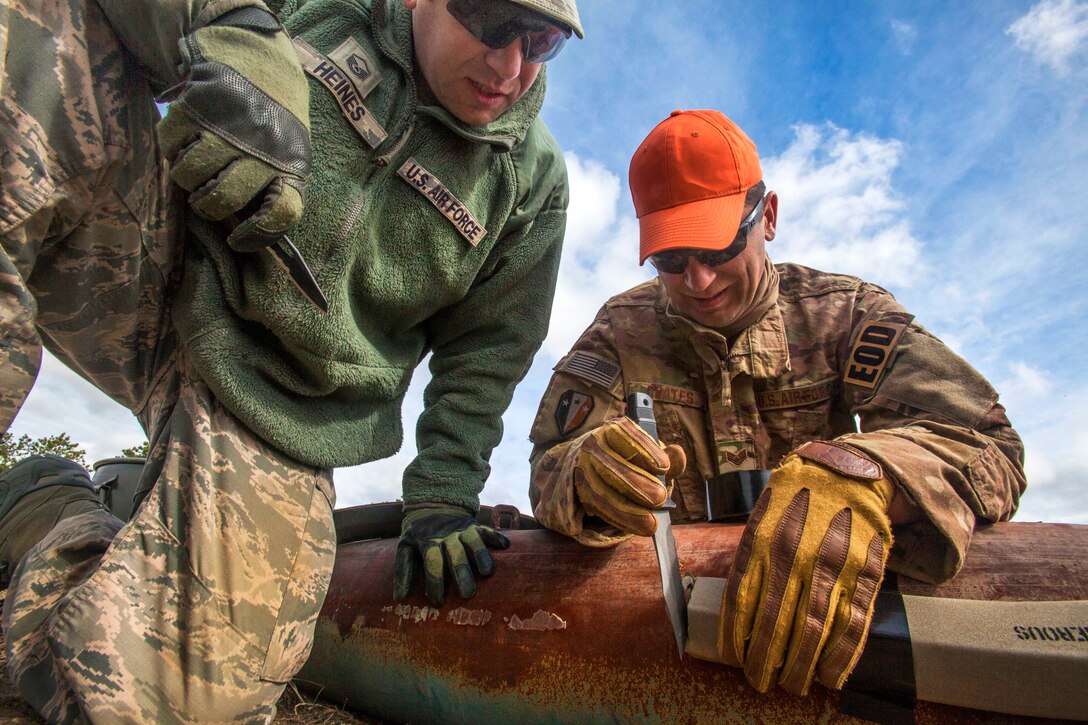 Air Force Reserve Master Sgt. Dustin Heines, left, watches New Jersey Air National Guard Staff Sgt. Joe Coates cut explosive cutting tape during a joint render safe operation at Warren Grove Gunnery Range, Joint Base McGuire-Dix-Lakehurst, N.J., May 1, 2015. Heines is assigned to the 514th Air Mobility Wing Explosive Ordnance Disposal team and Coates is assigned to the 177th Fighter Wing Explosive Ordnance Disposal team.