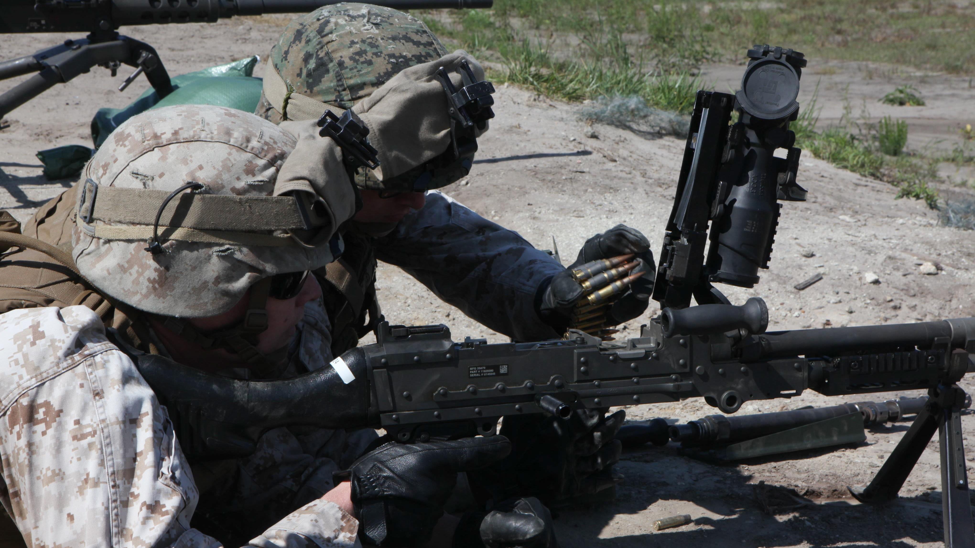Marines with the Machine Gunner's Course load an M240B medium machine gun during a live-