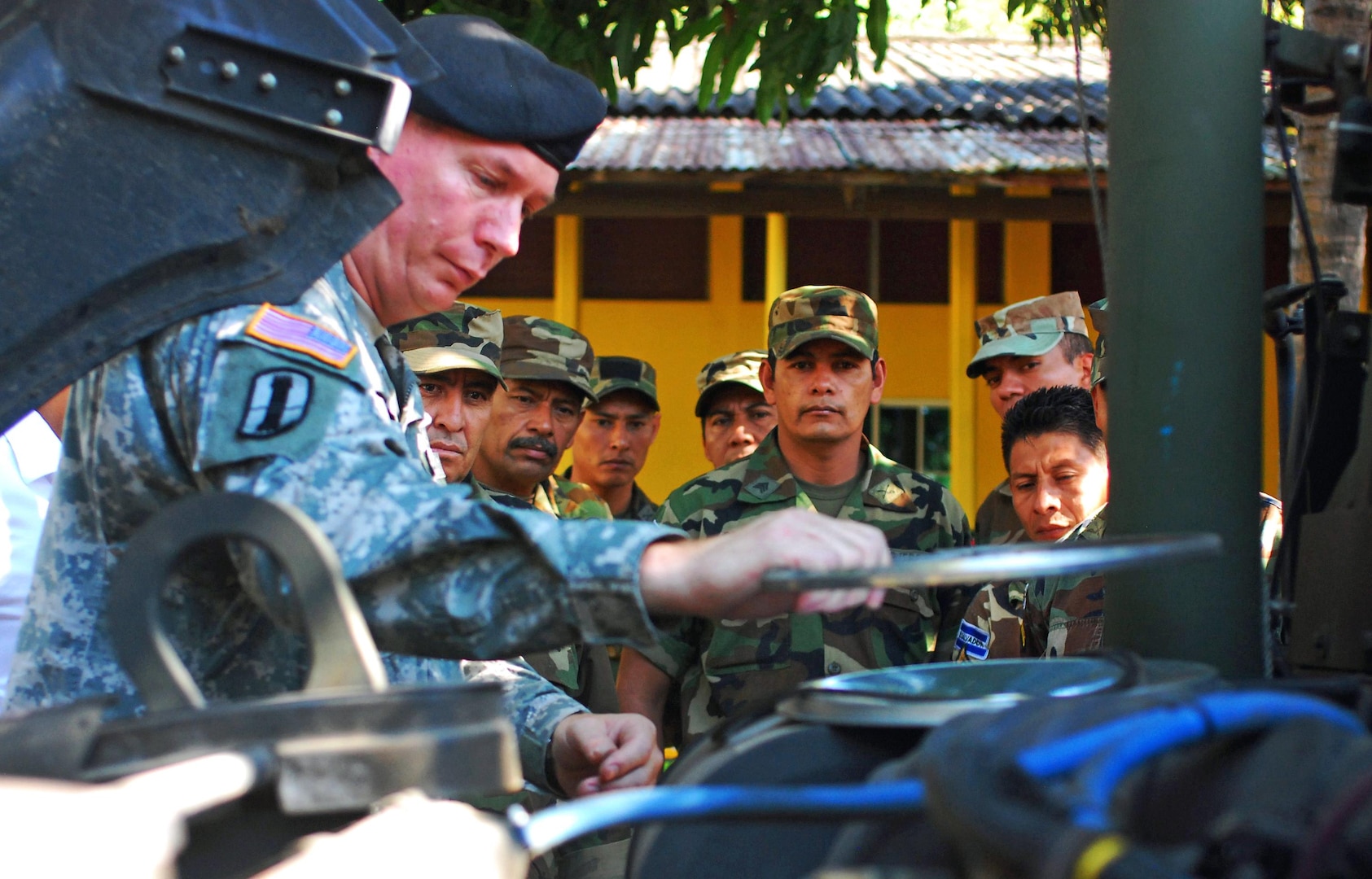 New Hampshire Army National Guard Chief Warrant Officer 4 Michael Tkacz disassembles the air filter of an 1165 High-Mobility Multi-Wheeled Vehicle with Salvadorian Army soldiers watching at the Salvadorian Calvary Regiment motor pool in La Libertad, El Salvador, Nov. 15, 2010.