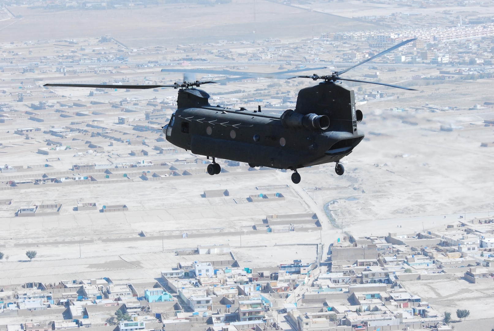 A 10th Combat Aviation Brigade CH-47 Chinook helicopter, operated by members of the Texas and Oklahoma National Guard, flies a personnel and equipment movement mission, Oct. 26, over Kabul, Afghanistan. A similar craft helped save stranded cattle on May 12, 2015.