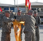U.S. Army Command Sgt. Maj. John M. Montgomery, the Task Force Morgan command sergeant major, and U.S. Army Lt. Col. Timothy J. Murphy, the TF Morgan commander, roll up the 1st Squadron, 172nd Cavalry Squadron colors to take back to St. Albans, Vt., during the transfer of authority ceremony here Nov. 30, 2010.