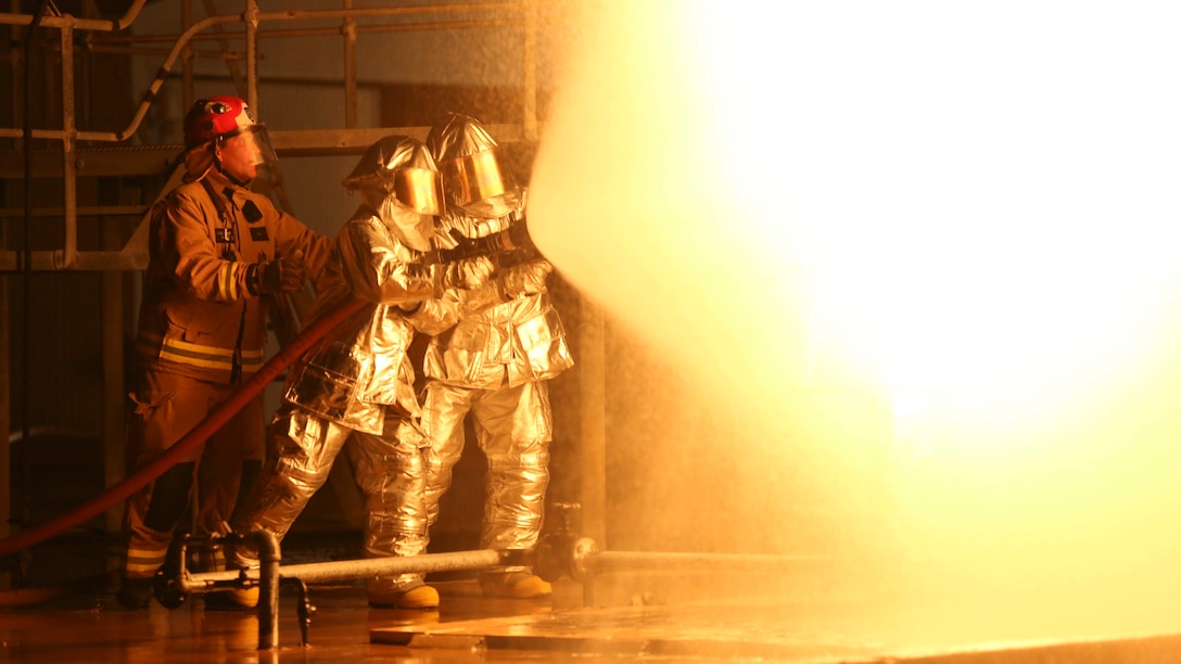 Marines with Marine Wing Support Squadron 171, Marine Rotational Force – Darwin, and an Australian firefighter with Aviation Rescue Firefighting Service, Airservices Australia, Darwin International Airport, practice extinguishing controlled chemical fires May 11 at RAFF Base Darwin, Darwin, Northern Territory, Australia. MWSS-171 is a part of the Marine Air - Ground Task Force that is composed of aviation, ground, and logistics combat elements, and lead by a command element, creating the MRF-D. The rotational deployment in Darwin enables Marines to more effectively train, exercise and operate with their partners, enhancing regional security and building a capacity to respond more rapidly to natural disasters and crises throughout that region. (U.S. Marine Corps photo by Cpl. Angel Serna/Released)