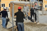 Maj. Trent Bruce, right, Directorate of Public Works (DPW) officer in charge, Master Sgt. Travis Vallery, center, also a member of DPW, talk with local Afghans, who were hired using the “Afghan First” program, about a project on Dec. 4, 2010, at Camp Phoenix in Kabul, Afghanistan. Bruce, Vallery and other members of DPW manage and oversee construction projects throughout the Kabul Base Cluster. 