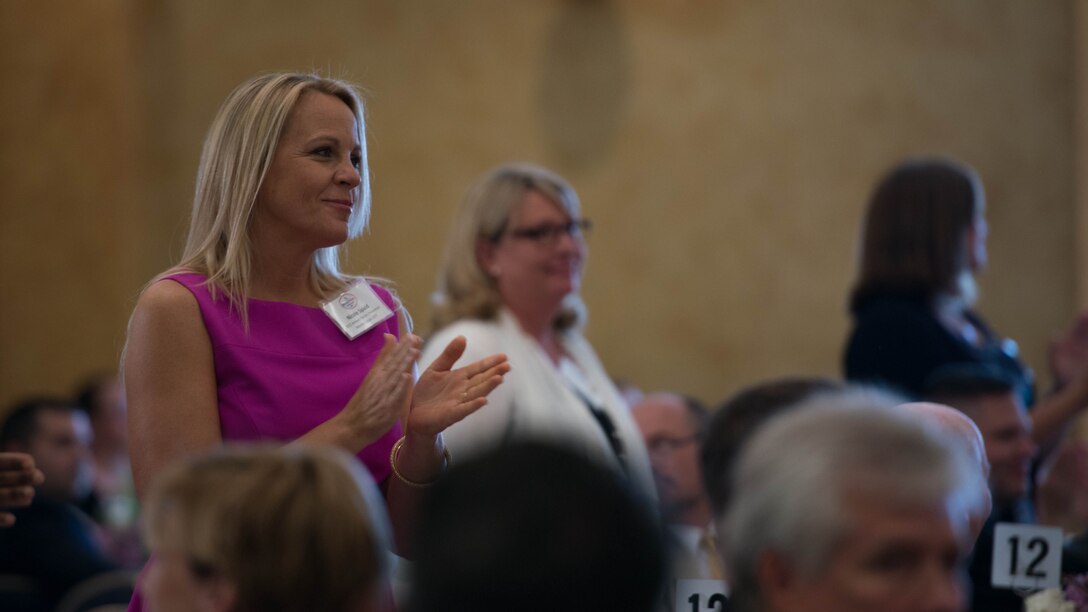 Nicole Spaid, the 2015 Armed Forces Insurance Marine Corps Spouse of the Year, claps as she and the other spouses of the year and previous years are recognized at the 8th Annual Awards Luncheon at Joint Base Myer- Henderson Hall, May 8, 2015. Spaid has overcome many obstacles in her life, including cancer, but has yet to stop reaching out to local spouses to encourage them to thrive.