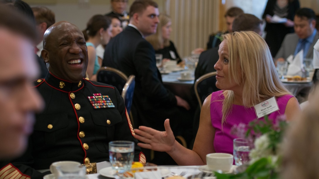 Nicole Spaid, the 2015 Armed Forces Insurance Marine Corps Spouse of the Year, and Sgt. Maj. Ronald Green, the 18th Sergeant Major of the Marine Corps, laugh during the meal portion of the 8th Annual Awards Luncheon at Joint Base Myer- Henderson Hall, May 8, 2015. Spaid has overcome many obstacles in her life, including cancer, but has yet to stop reaching out to local spouses to encourage them to thrive.