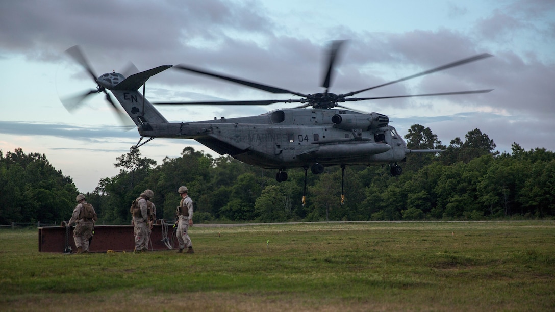 Landing support specialists with Combat Logistics Battalion 22, Headquarters Regiment, prepare to secure a simulated cargo load to a CH-53E Super Stallion helicopter during an external lift exercise on Landing Zone Albatross aboard Marine Corps Base Camp Lejeune, N.C., May 7, 2015. The exercise was performed in collaboration with the 2nd Marine Aircraft Wing and was intended to maintain readiness for future operations that will require them to efficiently transport equipment and supplies to units. 