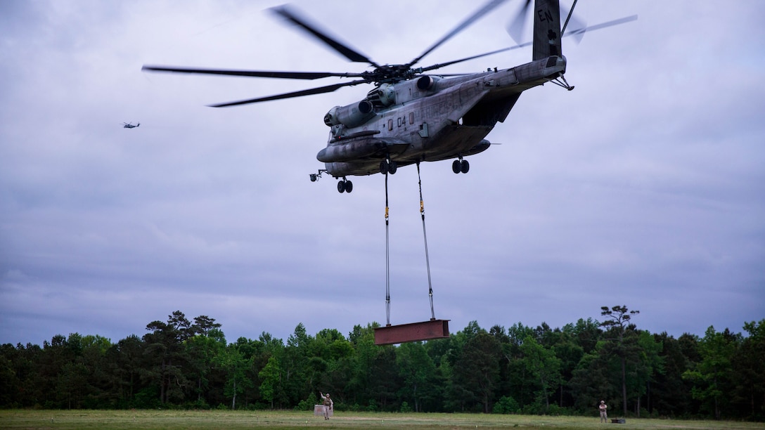 Landing support specialists with Combat Logistics Battalion 22, Headquarters Regiment, direct the landing of a CH-53E Super Stallion helicopter during an external lift exercise on Landing Zone Albatross aboard Marine Corps Base Camp Lejeune, N.C., May 7, 2015. The exercise was performed in collaboration with the 2nd Marine Aircraft Wing and is intended to maintain readiness for future operations that will require them to efficiently transport equipment and supplies to units. 