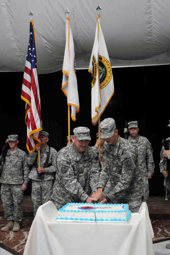 Maj. Gen. Nelson J. Cannon, left, commanding general for detainee operations
and provost marshal general with United States Forces-Iraq, and Pfc. Jacob
Wood, with Troop B, 2nd Squadron, 116th Garrison Command, U.S.
Division-Center, cut a cake with a sabre to celebrate the National Guard's
374th birthday inside Al Faw Palace at Camp Victory, Iraq, Dec. 13, 2010.
Cannon is currently the most senior ranking National Guard service member
and Wood is currently the most junior ranking National Guard service member
at Victory Base Complex, Iraq.