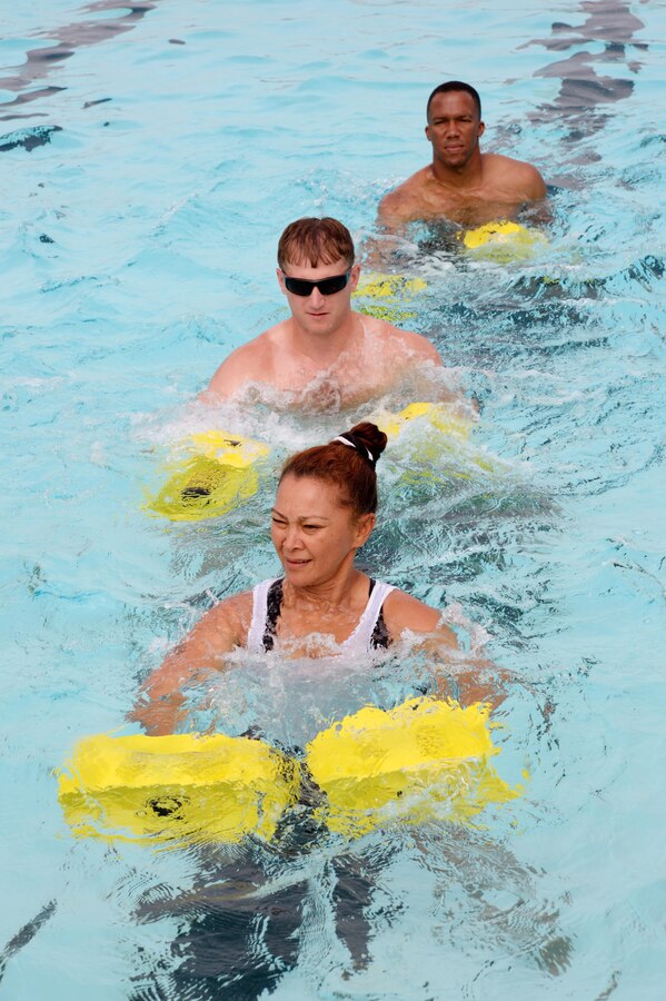 Jeania Lamonzs, (front) lead instructor, Aquatics Maximum Power-Intense Training, Marine Corps Community Services, performs physical fitness exercises with Marines during AMP-IT training, May 13, at the Base Pool. The two Marines were among a group who will become future AMP-IT instructors and be able to train their Marines on the no-impact exercises.