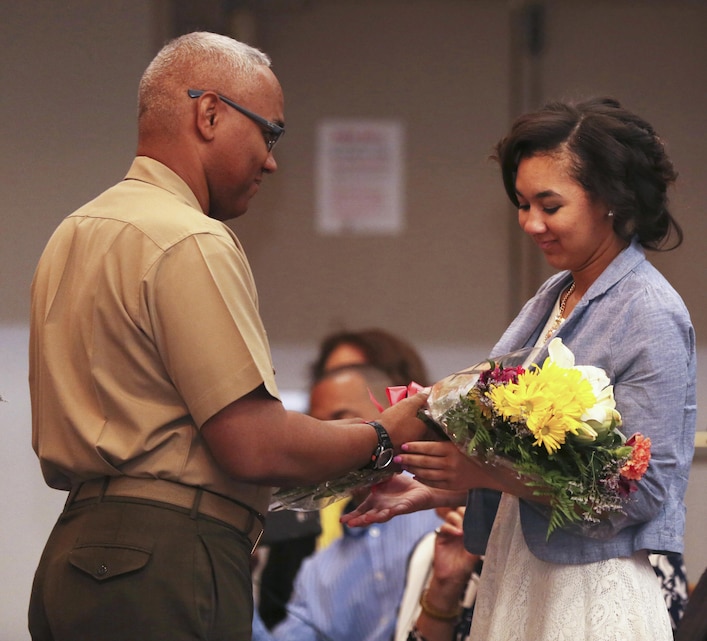 Lt. Col. Christopher L. Page, former assistant chief of staff, G8 Comptroller, presents his daughter, Brianna Page, a bouquet of flowers during his retirement ceremony at the Protestant Chapel, May 8, 2015. Page retired after 26 years of honorable service in the Marine Corps. (Official Marine Corps photo by Lance Cpl. Medina Ayala-Lo/Released)