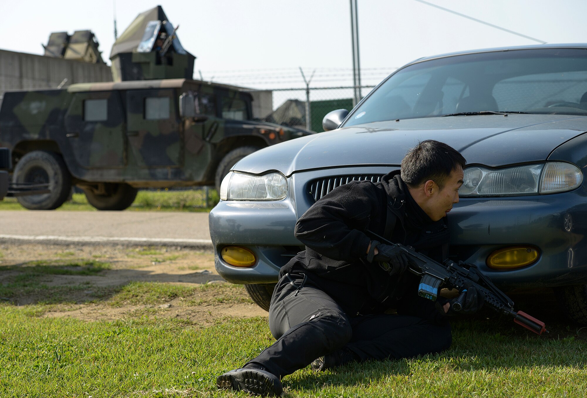 A Republic of Korea personnel hides from an armed vehicle during a simulated opposition forces attack during operational readiness exercise Beverly Midnight 15-02 May 13, 2015, at Osan Air Base, Republic of Korea. (U.S. Air Force photo by Staff Sgt. Jake Barreiro)