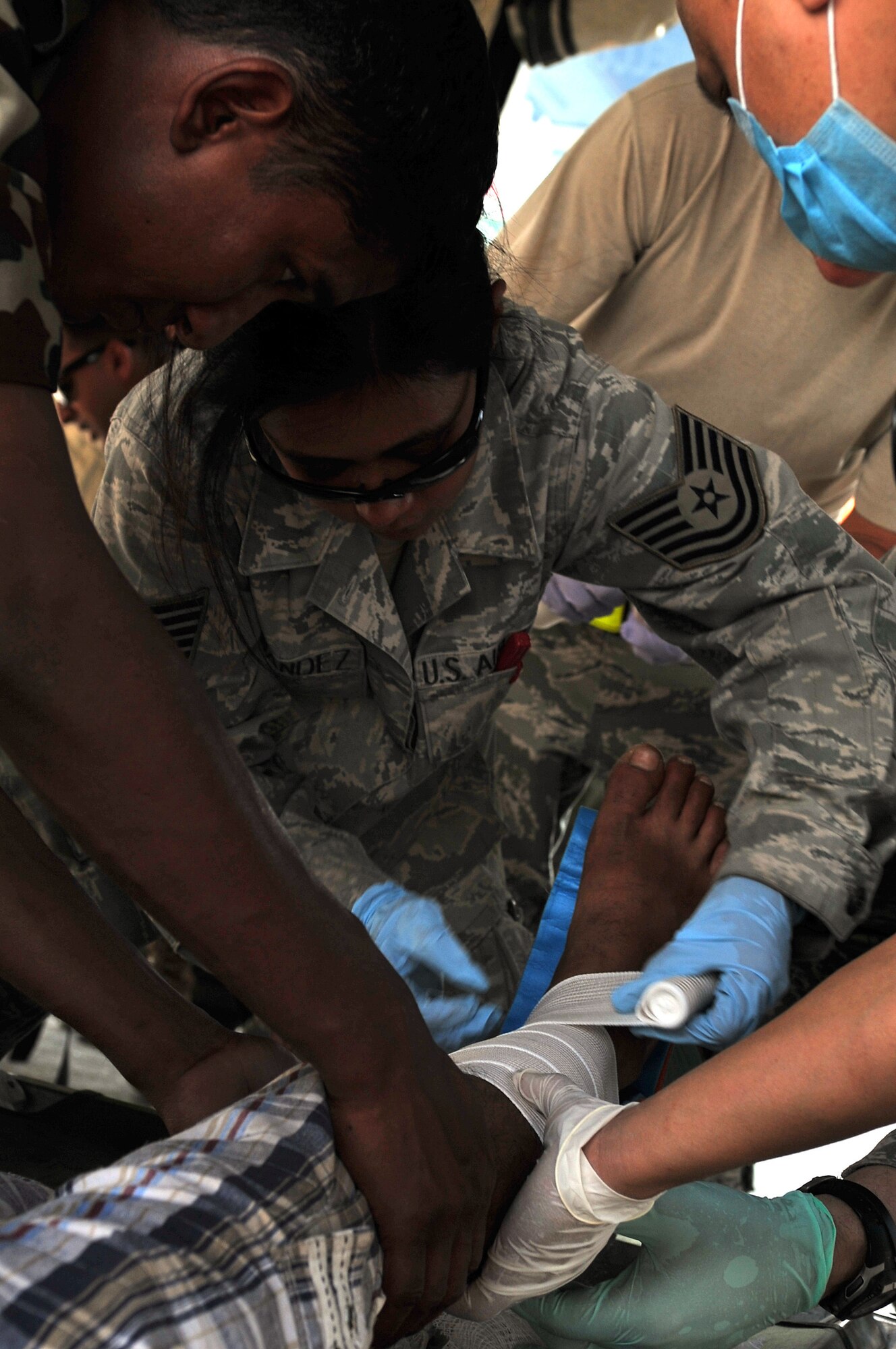 U.S. Air Force Tech Sgt. Honorata Fernandez, 36th Contingency Response Group independent duty medical technician, helps Nepalese army soldiers splint an earthquake victim's leg at the Tribhuvan International Airport in Kathmandu, Nepal, May 12, 2015. Joint Task Force-505 members worked with the Nepalese army to triage, treat and transport patients after a 7.3 magnitude earthquake struck the same day following a 7.8 magnitude earthquake that devastated the nation April 25, 2015. (U.S. Air Force photo by Staff Sgt. Melissa B. White/Released)