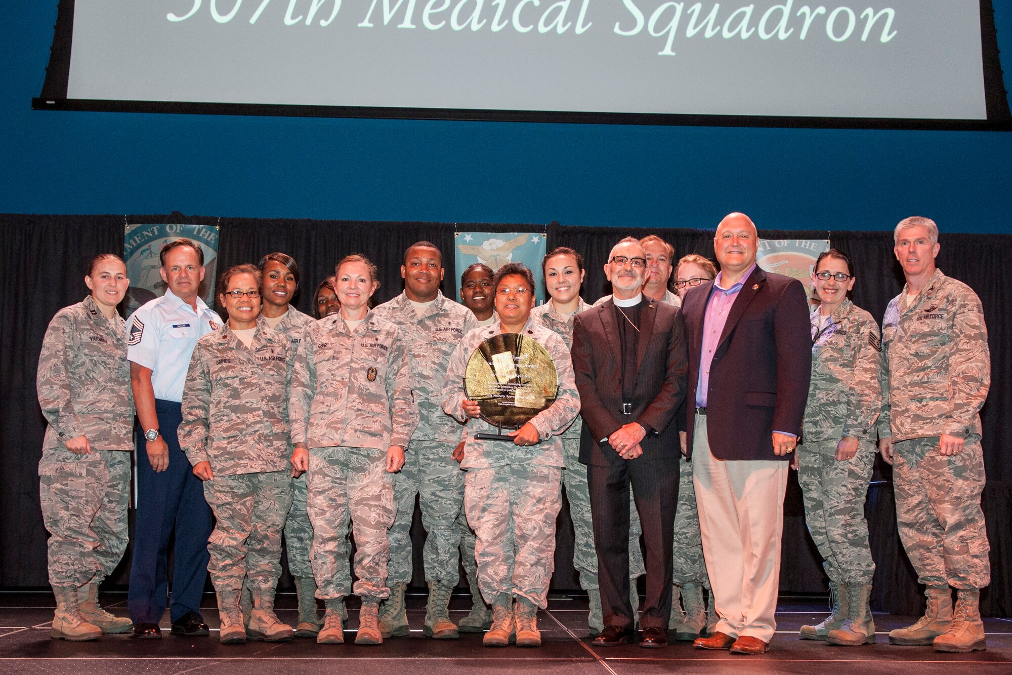 U.S. Air Force Airmen from the 307th Medical Squadron are awarded the Unit of Excellence Award from the Bossier City Chamber of Commerce on May 13, 2015, Bossier City, La. The Chamber recognized the top units from the Army, Navy, Marines and Air Force in the local area during their Military Appreciation Breakfast. The event was aimed to educate the community on local units serving in their back yard, and also provide insight into various jobs that military members perform each day. (U.S. Air Force photo by Master Sgt. Dachelle Melville/Released)