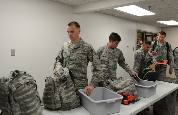 Airmen prepare their gear before processing through a checkpoint during a Constant Vigilance deployment exercise at Barksdale Air Force Base, Louisiana, May 5, 2015. Air Force Global Strike Command conducts training operations and exercises on a regular basis to ensure its forces are ready to perform nuclear deterrence operations and long-range strike missions if and when called upon to do so. (U.S. Air Force photo/Senior Airman Benjamin Gonsier)
