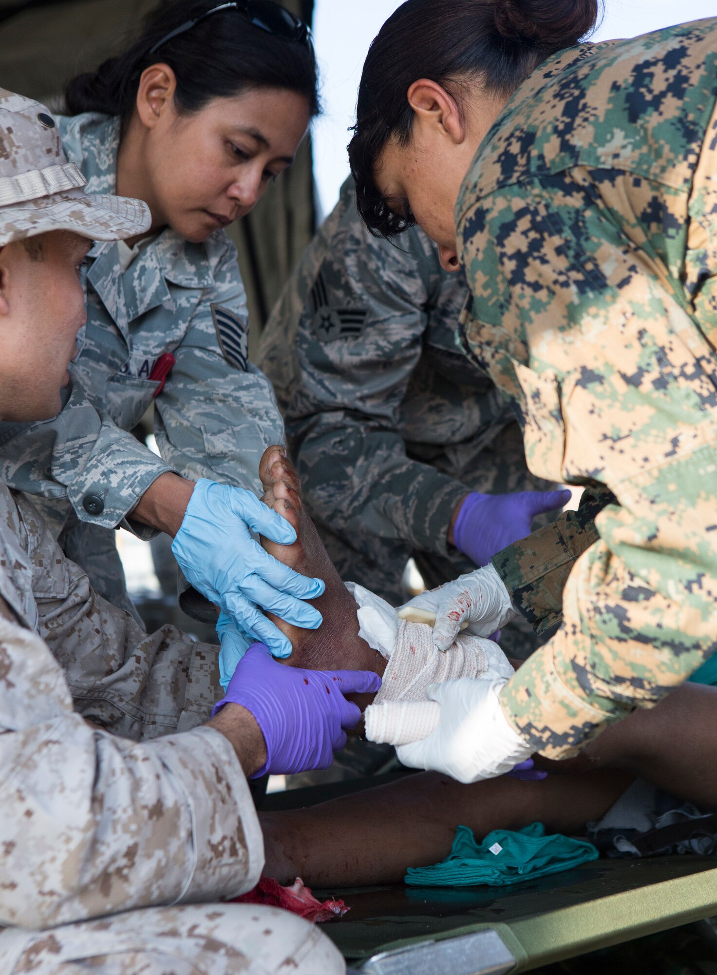 U.S. Service members with Joint Task Force-505 provide aid to an earthquake victim at a medical triage area at Tribhuvan International Airport, Kathmandu, Nepal, after a 7.3 magnitude earthquake struck the country, May 12, 2015. JTF-505 along with other multinational forces and humanitarian relief organizations are currently in Nepal providing aid after a 7.8 magnitude earthquake struck the country, April 25, 2015. At Nepal's request the U.S. government ordered JTF-505 to provide unique capabilities to assist Nepal. (U.S. Marine Corps photo by MCIPAC Combat Camera Staff Sgt. Jeffrey D. Anderson/Released)