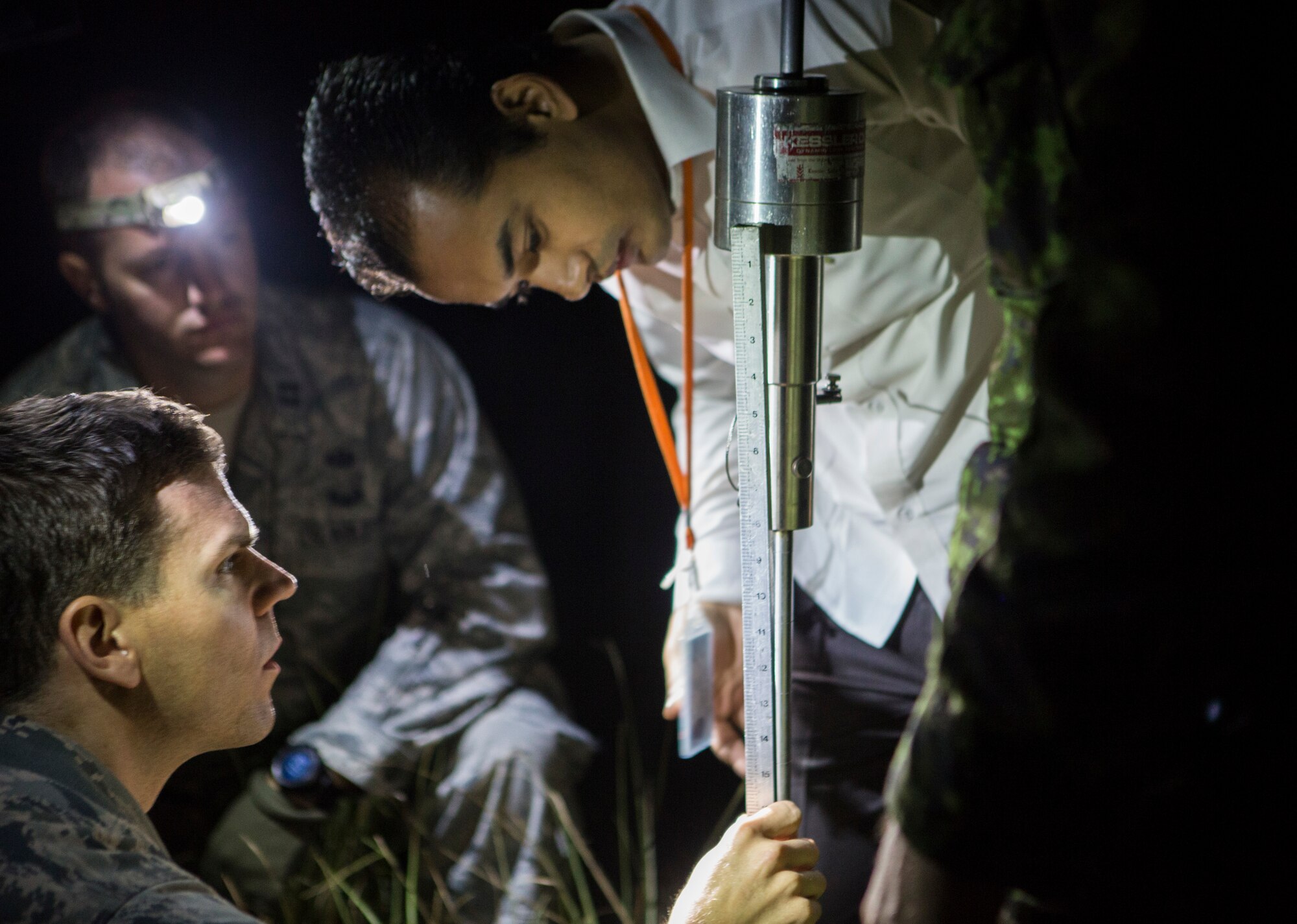 Kumar Shresthna, a Nepalese civil engineer with the Civil Aviation Authority of Nepal, and U.S. Air Force Tech. Sgt. Mark Hoover, an airfield manager with the 36th Contingency Response Group, Joint Task Force-505 and Naples, Florida-native, take measurements used to determine the geotechnical engineering properties of the soil at the Tribhuvan International Airport, Kathmandu, Nepal, May 8, 2015. The team tested the soil using a dynamic cone penetrometer to determine its stability following the 7.8 magnitude earthquake that struck Nepal, April 25, 2015. The pavement evaluation tested to see if there were any significant changes to the soil beneath the runway since the earthquake. Any changes could restrict weight limitations to incoming flights in order to prevent any runway damage. JTF-505 works in conjunction with USAID and the international community to provide unique capabilities to assist Nepal. (U.S. Marine Corps photo by MCIPAC Combat Camera Staff Sgt. Jeffrey D. Anderson/Released)