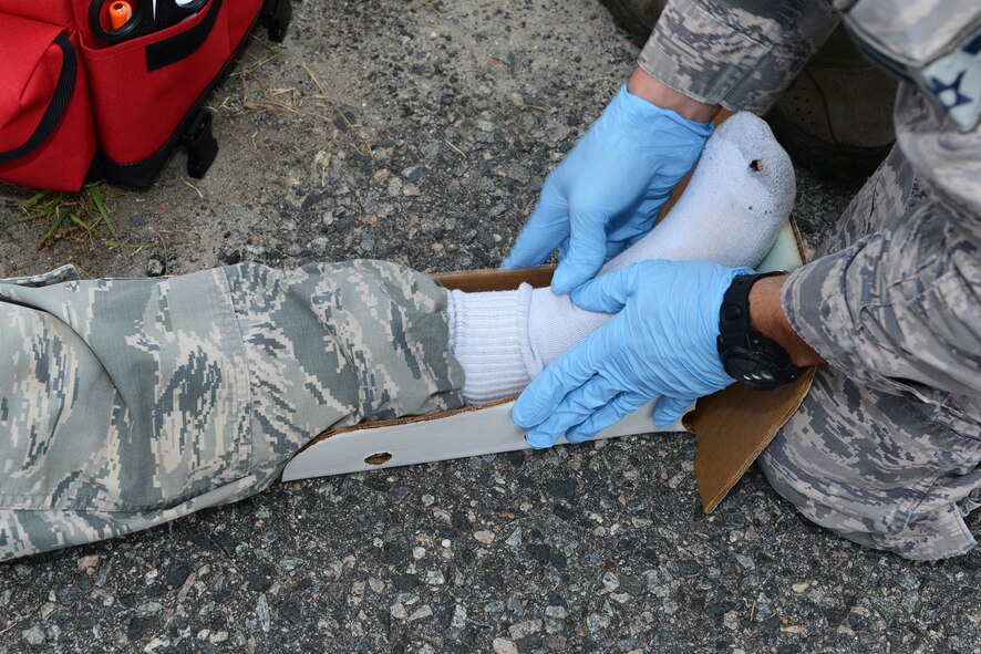 U.S. Air Force Airman 1st Class Brandon Diberardino, 23d Civil Engineer Squadron firefighter, places Staff Sgt. Bullard’s, 23d CES water fuel system maintenance technician, leg in a splint during the Hurricane Response exercise May 13, 2015, at Moody Air Force Base, Ga. Testing the first responders on their performance prepares them to function and make decisions in a stressful situation. (U.S. Air Force photo by Airman 1st Class Kathleen D. Bryant/Released)



