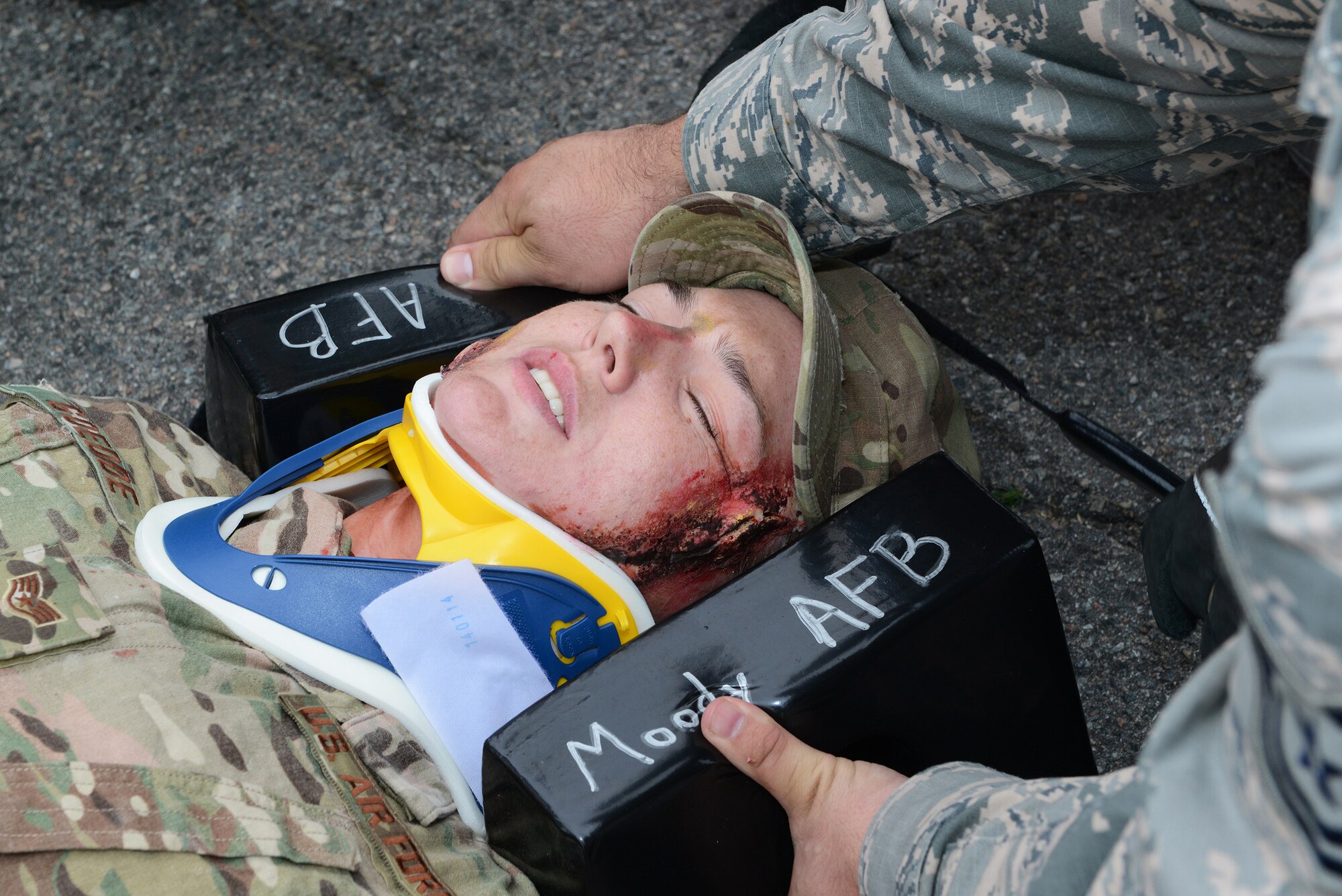 A Moody first responder secures the head and neck of U.S. Air Force Staff Sgt. Amber Goedde, 23d Explosive Ordnance Disposal flight craftsman, during the Hurricane Response exercise May 13, 2015, at Moody Air Force Base, Ga. Testing the base's response to a natural disaster helps ensure all agencies are adequately trained and ready for a real-world event. (U.S. Air Force photo by Airman 1st Class Kathleen D. Bryant/Released)
