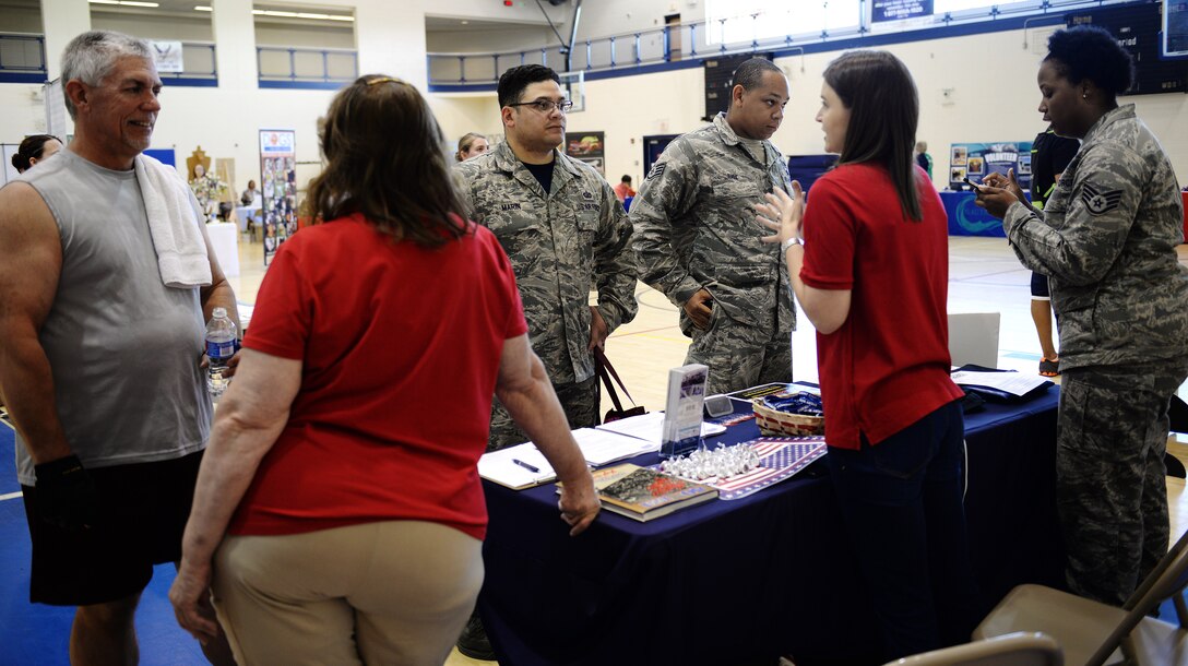 Representatives from the United Service Organizations speak with those interested in volunteering during a volunteer fair at Langley Air Force Base, Va., May 8, 2015. The event brought together more than 40 organizations to provide information about volunteer opportunities in the community. (U.S. Air Force photo by Staff Sgt. Teresa J. Cleveland/Released)