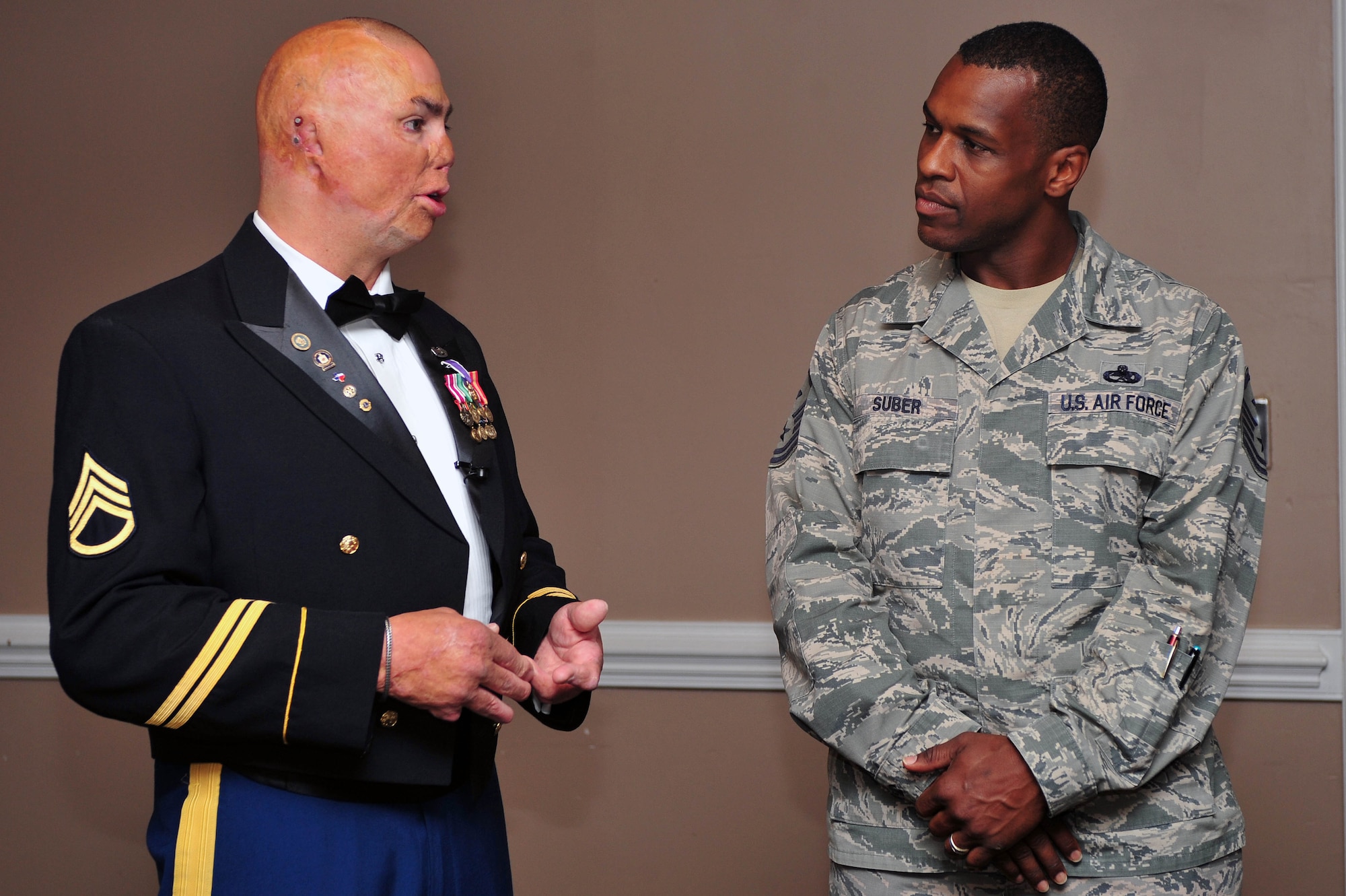 Retired Army Staff Sgt. Shilo Harris speaks with Master Sgt. Brandon Suber, 4th Medical Group first sergeant, prior to the National Prayer Breakfast, May 7, 2015, at Seymour Johnson Air Force Base, North Carolina. Harris shared his story with members of Team Seymour to raise awareness about post-traumatic stress disorder. (U.S. Air Force photo/Senior Airman John Nieves Camacho)