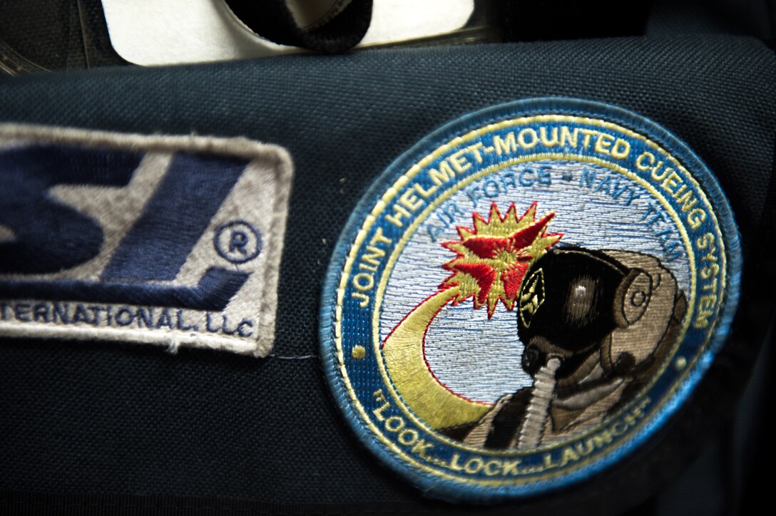 A patch mounted to a helmet bag from the Royal Canadian air force’s 425th Tactical Fighter Squadron, shows it holds the joint helmet-mounted cueing system (JHMCS) for a CF-18 Hornet pilot at Eielson Air Force Base, Alaska, May 7, 2015, during RED FLAG-Alaska (RF-A) 15-2. The JHMCS combines a magnetic head tracker with a display projected onto a pilot's visor, giving the pilot a targeting device that can be used to aim sensors and weapons wherever the pilot is looking. (U.S. Air Force photo by Staff Sgt. Shawn Nickel/Released)