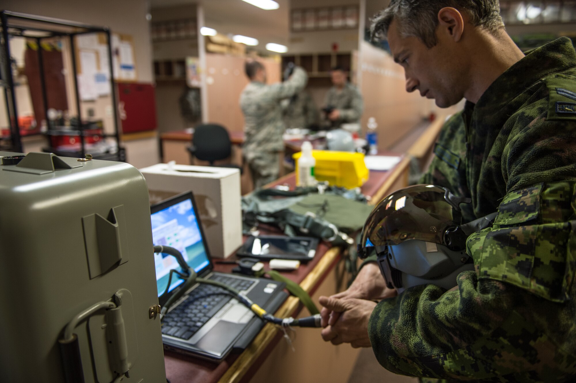 Royal Canadian air force Cpl. Yannick Deschesnes, an aircrew flight equipment technician from the 425th Tactical Fighter Squadron, tests a joint helmet-mounted cueing system for a CF-18 Hornet pilot at Eielson Air Force Base, Alaska, May 7, 2015, during RED FLAG-Alaska (RF-A) 15-2. After testing and certifying aircrew flight equipment, Deschesnes will transition to the role of crew chief and launch jets during RF-A to reduce the amount of manning required while on temporary duty. (U.S. Air Force photo by Staff Sgt. Shawn Nickel/Released)