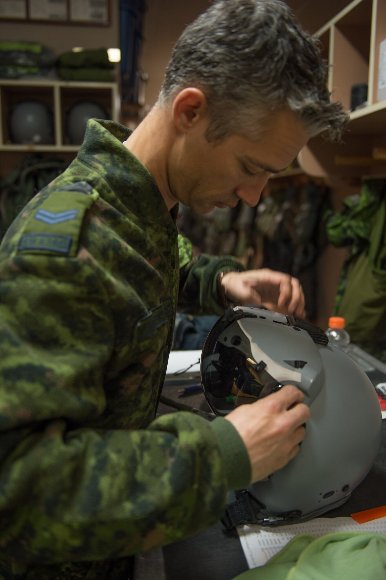 Royal Canadian air force Cpl. Yannick Deschesnes, an aircrew flight equipment technician from the 425th Tactical Fighter Squadron, assembles a joint helmet-mounted cueing system (JHMCS) for a CF-18 Hornet pilot at Eielson Air Force Base, Alaska, May 7, 2015, during RED FLAG-Alaska (RF-A) 15-2. The JHMCS combines a magnetic head tracker with a display projected onto a pilot's visor, giving the pilot a targeting device that can be used to aim sensors and weapons wherever the pilot is looking. (U.S. Air Force photo by Staff Sgt. Shawn Nickel/Released)
