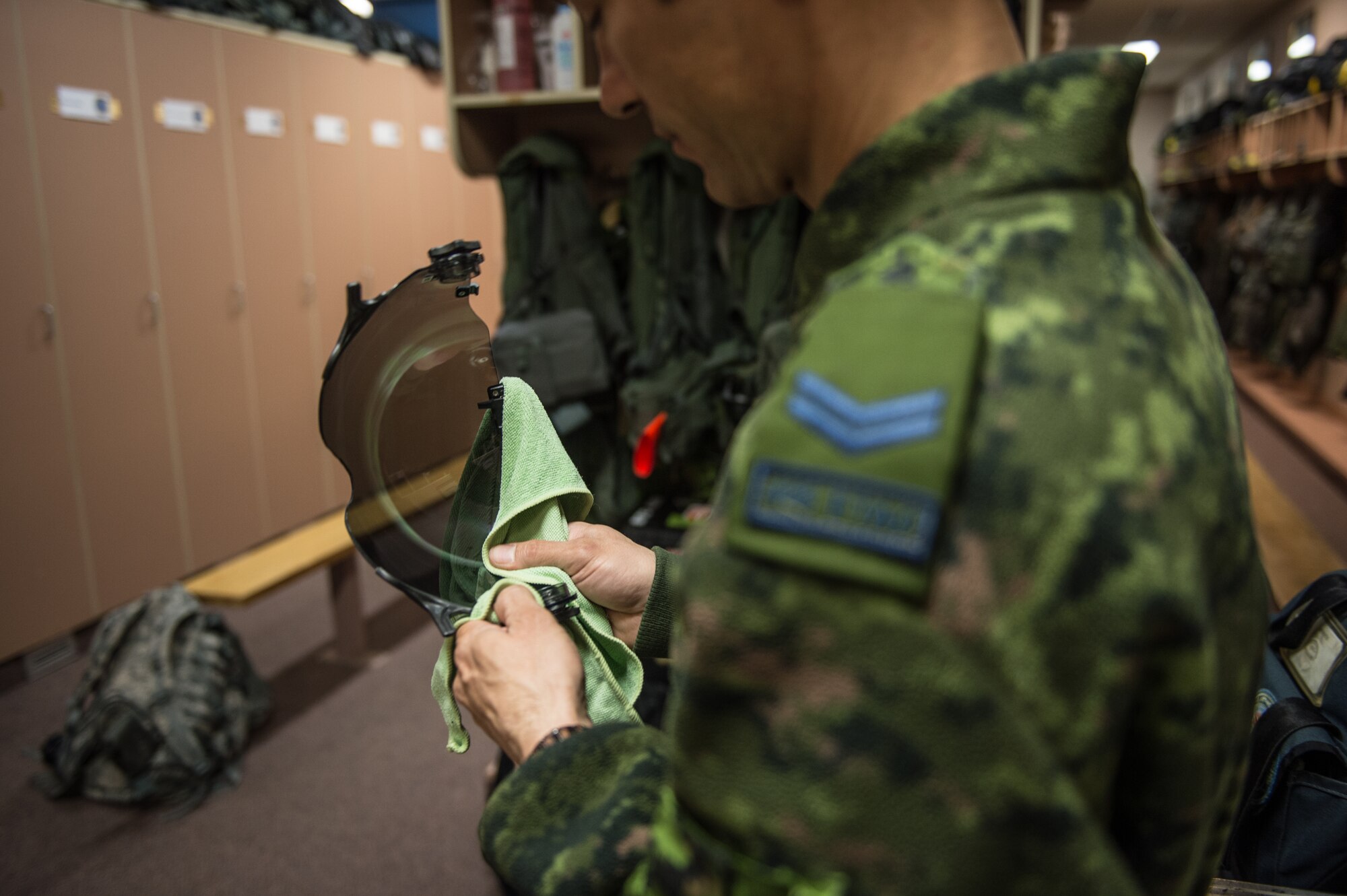 Royal Canadian air force Cpl. Yannick Deschesnes, an aircrew flight equipment technician with the 425th Tactical Fighter Squadron, polishes a visor for a CF-18 Hornet pilot’s helmet at Eielson Air Force Base, Alaska, May 7, 2015, during RED FLAG-Alaska (RF-A)15-2. The work completed by maintenance personnel ensures mission-capable aircraft and equipment for pilots so they can provide air support, serving a vital role in the overall RF-A mission. (U.S. Air Force photo by Staff Sgt. Shawn Nickel/Released)