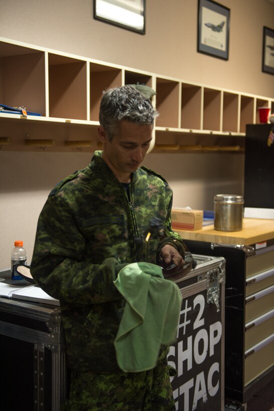 Royal Canadian air force (RCAF) Cpl. Yannick Deschesnes, 425th Tactical Fighter Squadron, polishes a visor for a CF-18 Hornet pilot’s helmet at Eielson Air Force Base, Alaska, May 7, 2015, during RED FLAG-Alaska 15-2. Deschesnes is an aircrew flight equipment technician, but also holds four other maintenance positions within the RCAF. (U.S. Air Force photo by Staff Sgt. Shawn Nickel/Released)

