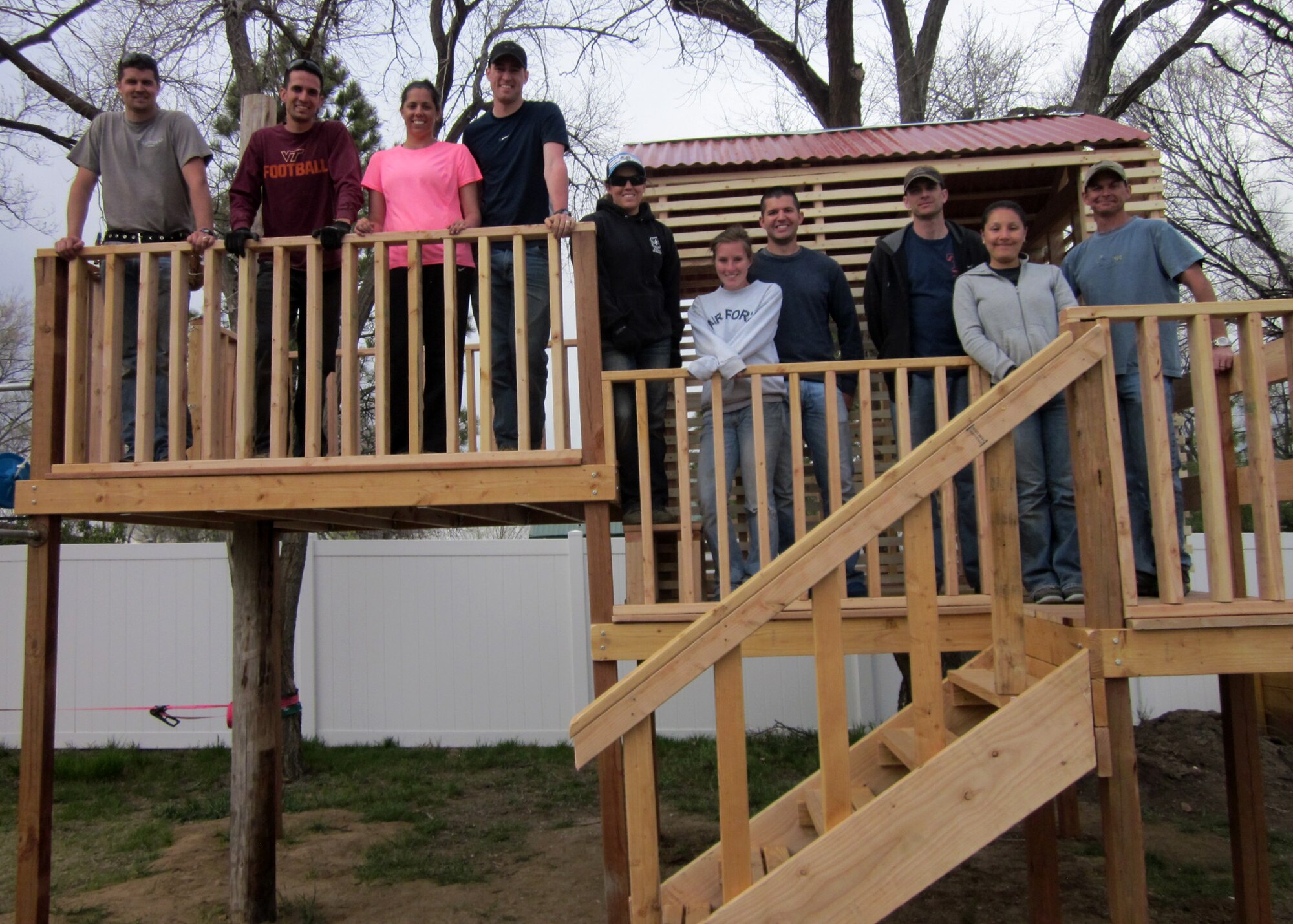 PETERSON AIR FORCE BASE, Colo. – Members of the Company Grade Officer’s Council pose for a photograph after completing a playground for Sarah’s Home, April 25, 2015. The volunteers designed and built an elevated club house, zip line, high bars, dual swings and a tight rope for the home that fosters underage female sex trafficking victims. (Courtesy photo by Pati Nuce)