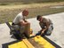 Staff Sgt. Walter Pinkerton (left), 403rd Civil Engineer Squadron water and fuels system management craftsman, and Senior Airman Nathin Schuessler, 403rd CES structural journeyman, repaint faded lines on the airfield taxiways May 5 at the 53rd Weather Reconnaissance Squadron “Hurricane Hunters” forward operating location at the Henry E. Rohlsen Airport, St. Croix, U.S. Virgin Islands. This is slated to be the last storm season for the civil engineers to maintain the facility in St. Croix due to the 403rd CES scheduled inactivation Sept. 15, 2015. (Courtesy photo)