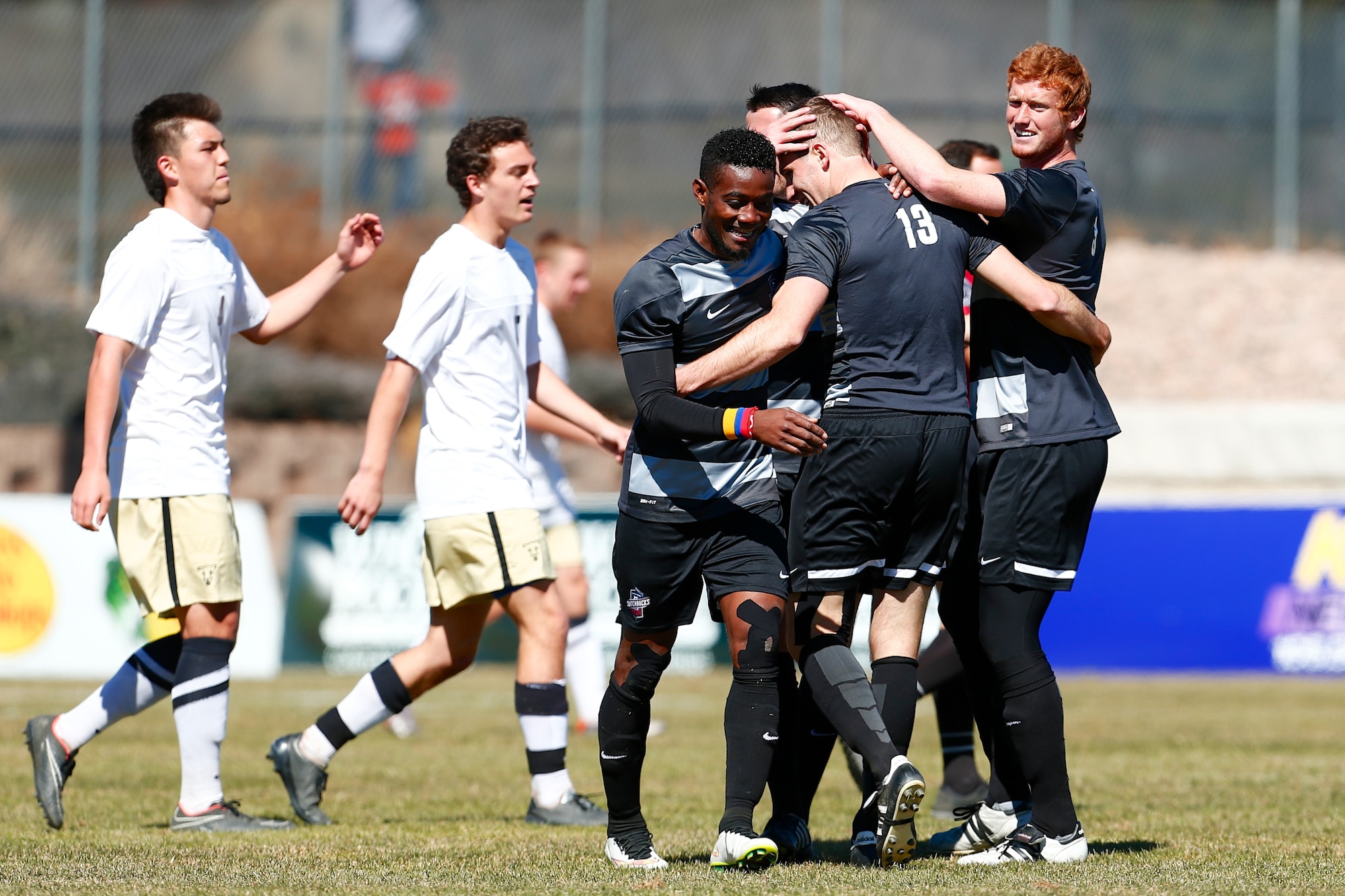 COLORADO SPRINGS, Colo. -- 2nd Lt. Kevin Durr, a software project manager with the Air Force Life Cycle Management Center and stationed at Peterson AFB, is congratulated by teammates during a tune up game against University of Colorado-Colorado Springs soccer team. Durr, wearing number 13, led the Air Force Academy team to the NCAA tournament in 2012 and is a member of the Colorado Springs Switchbacks professional football club. (Courtesy photo)