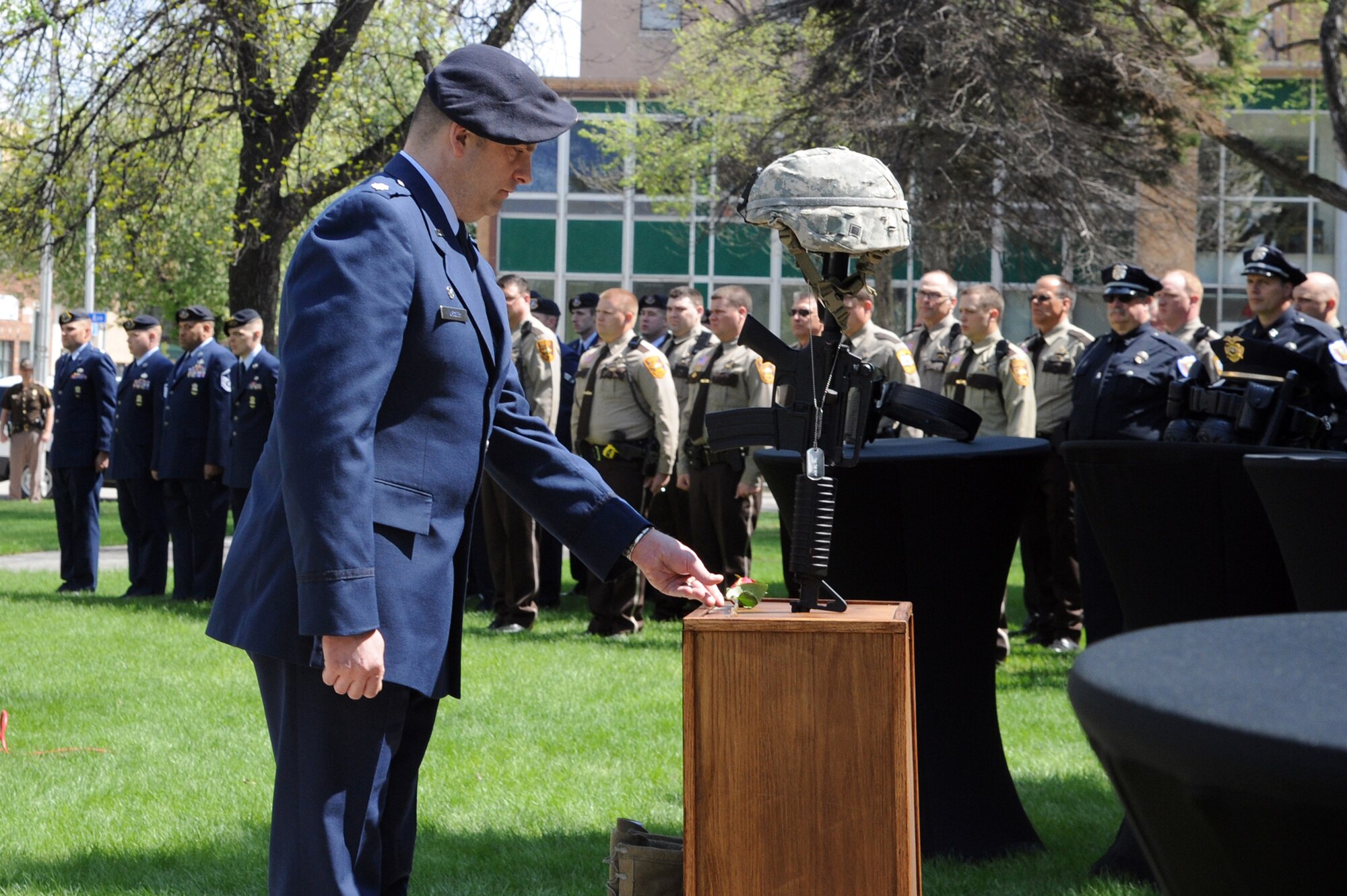Lt. Col. Jeffrey Becker, 319th Security Forces Squadron commander, places a rose on a memorial to fallen U.S. Air Force Security Forces Airmen during the annual Police Week memorial ceremony in Grand Forks, N.D., May 12, 2015. Becker and a detachment from the 319th SFS attended the ceremony in solidarity with fellow police forces from the United States and Canada. (U.S. Air Force photo by Staff Sgt. David Dobrydney/released)