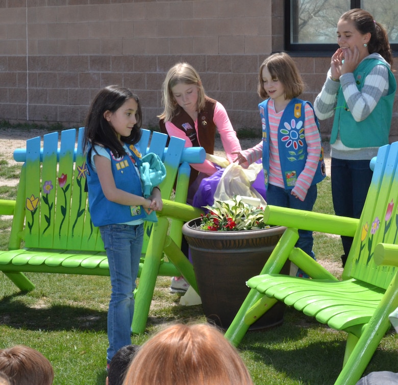 Natalie Moore (left), a Schriever housing resident and fourth grade student at Ellicott Elementary School, unveils the Buddy Benches she created and donated to the school as part of a community service project to earn her Girl Scouts Bronze Award May 11, 2015, at Ellicott, Colo. Students sit on the bench when they are feeling lonely and looking for a friend. (U.S. Air Force photo/Brian Hagberg)
