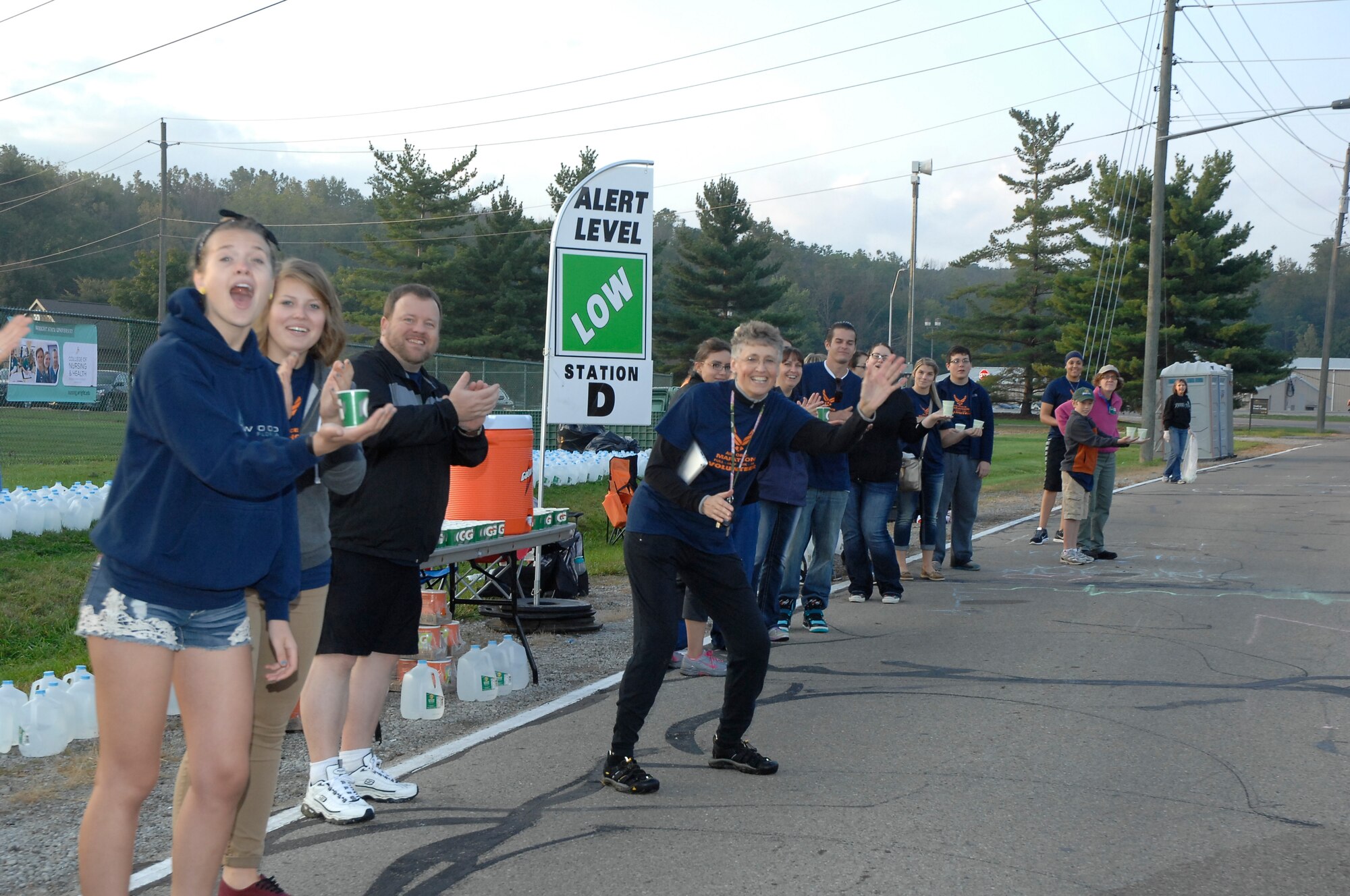 Volunteers pass out water and cheer runners at the 2014 U.S. Air Force Marathon.  U.S. Air Force Photo by Al Bright.